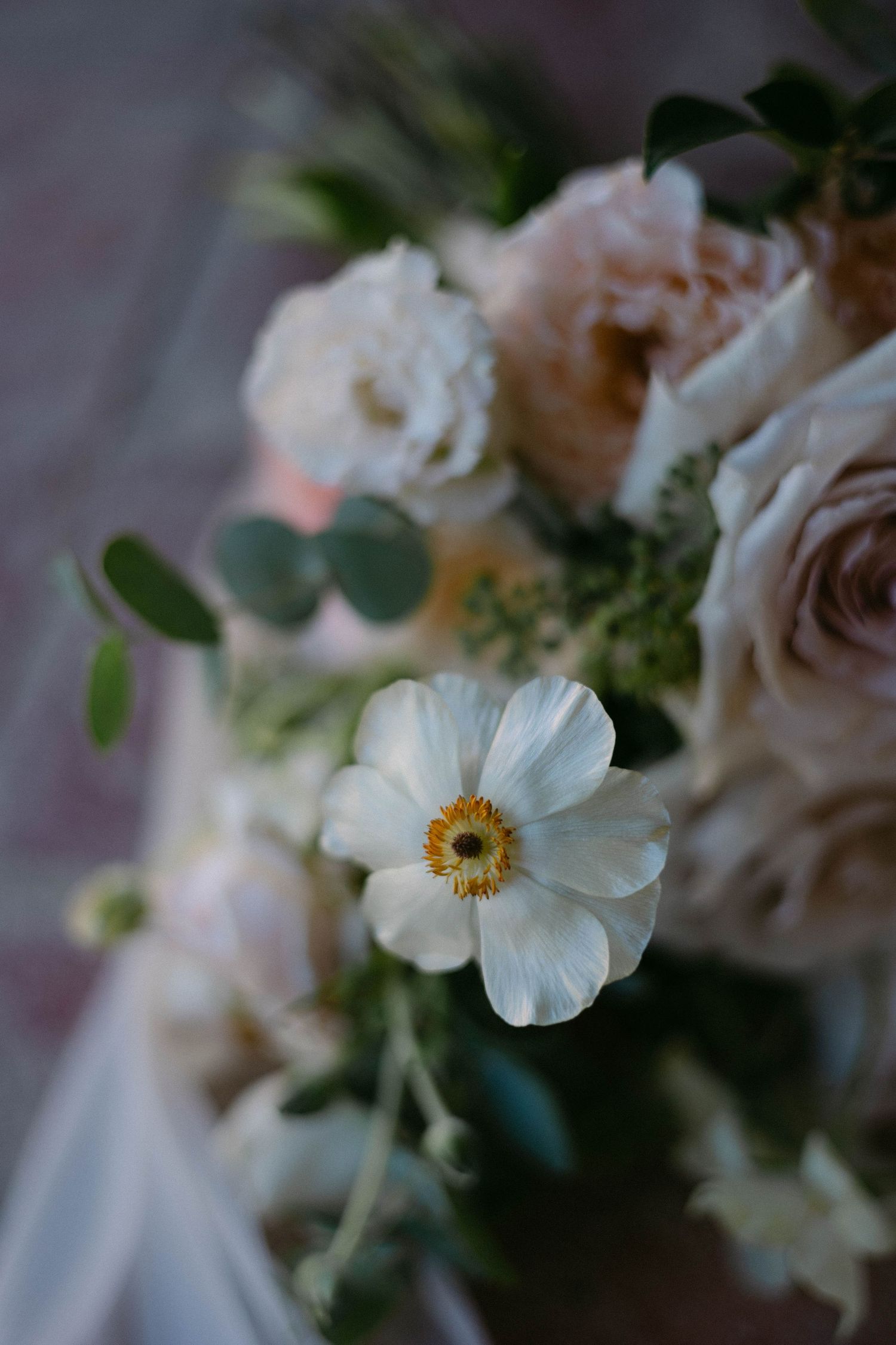 Delicate white and blush flowers arranged in an elegant wedding bouquet display.