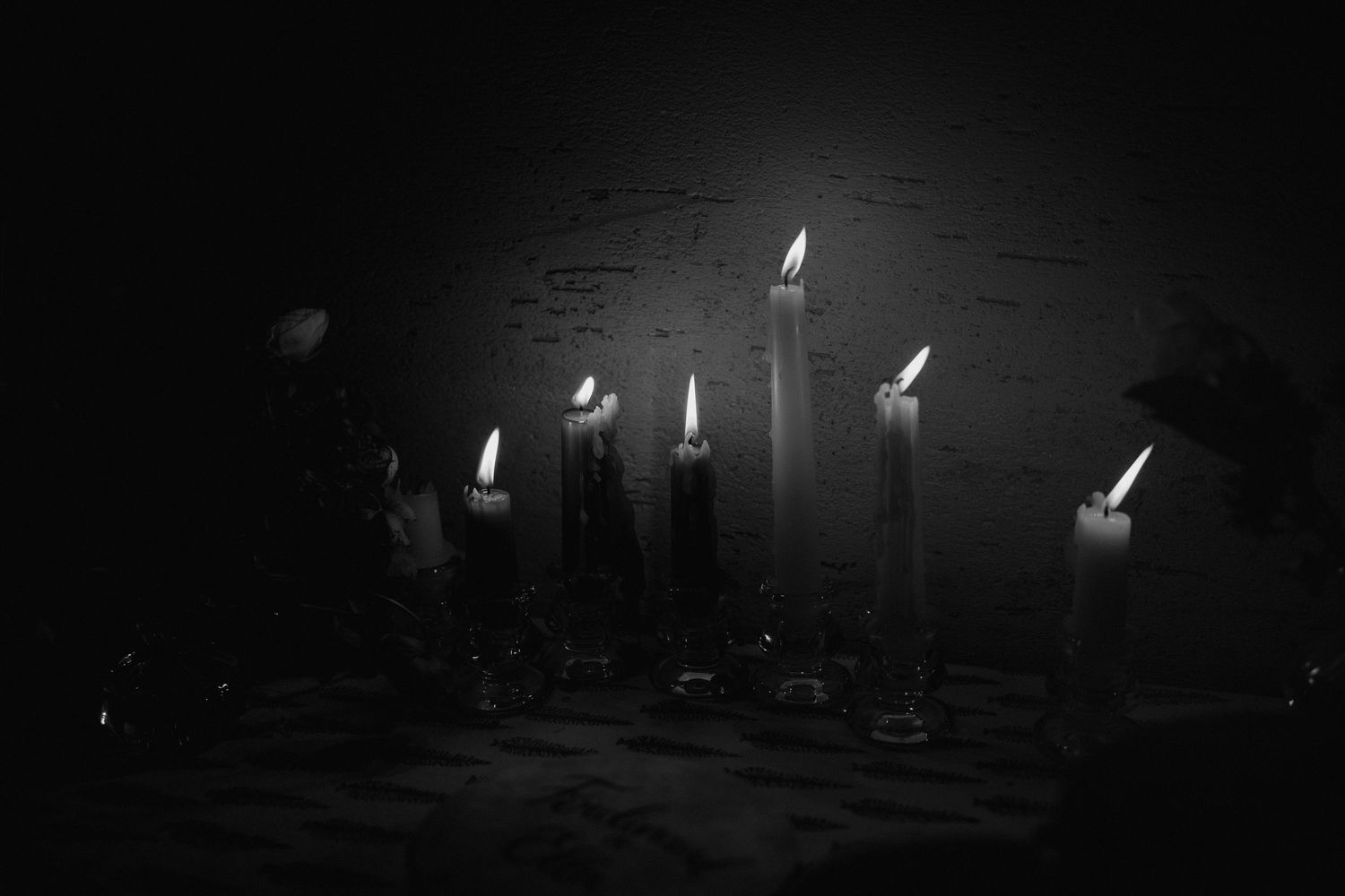 Dark silhouettes of wedding guests dancing against a black background with string lights.
