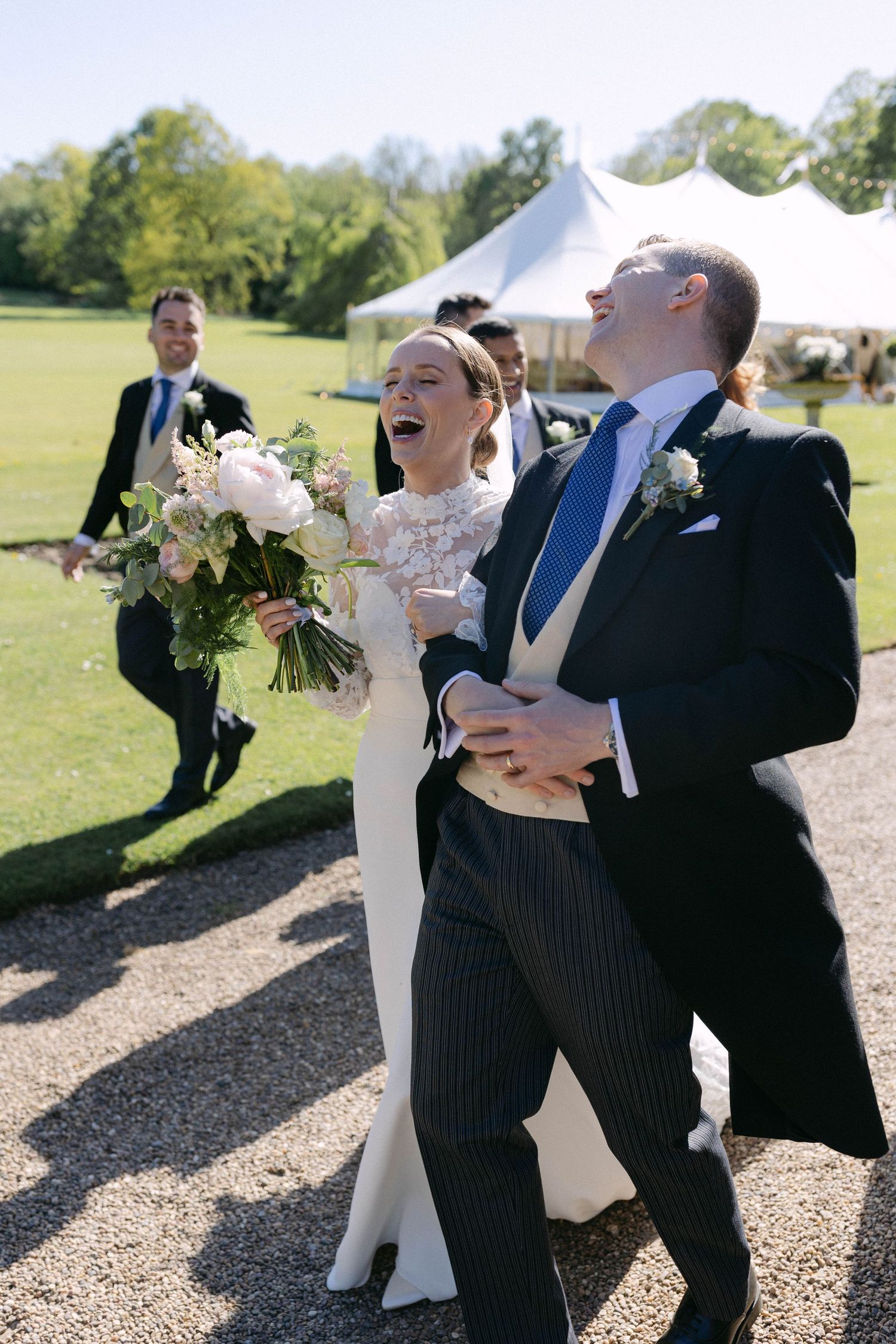 Joyful celebration on a sunny day with a white tent in the background.