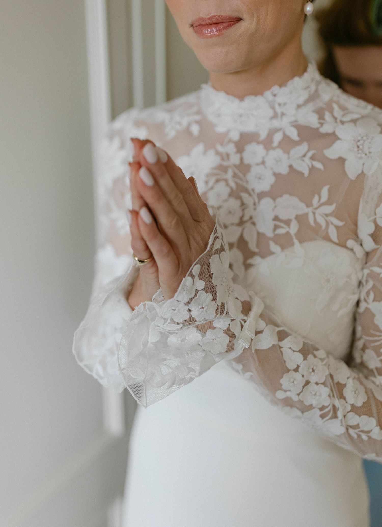 Close-up detail of delicate white lace appliques on sheer wedding dress fabric.