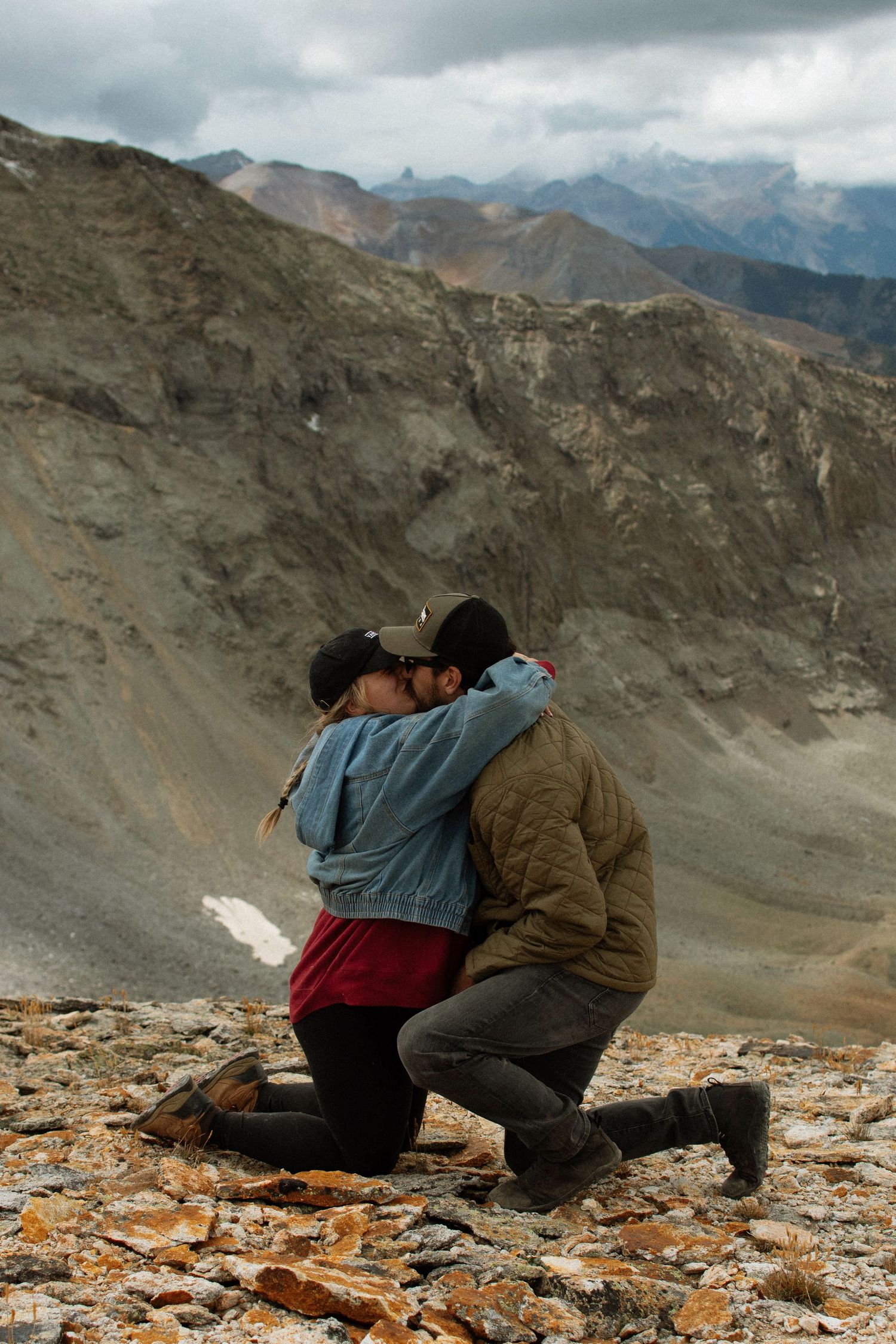 Couple sharing emotional embrace during mountain top marriage proposal. Telluride Colorado