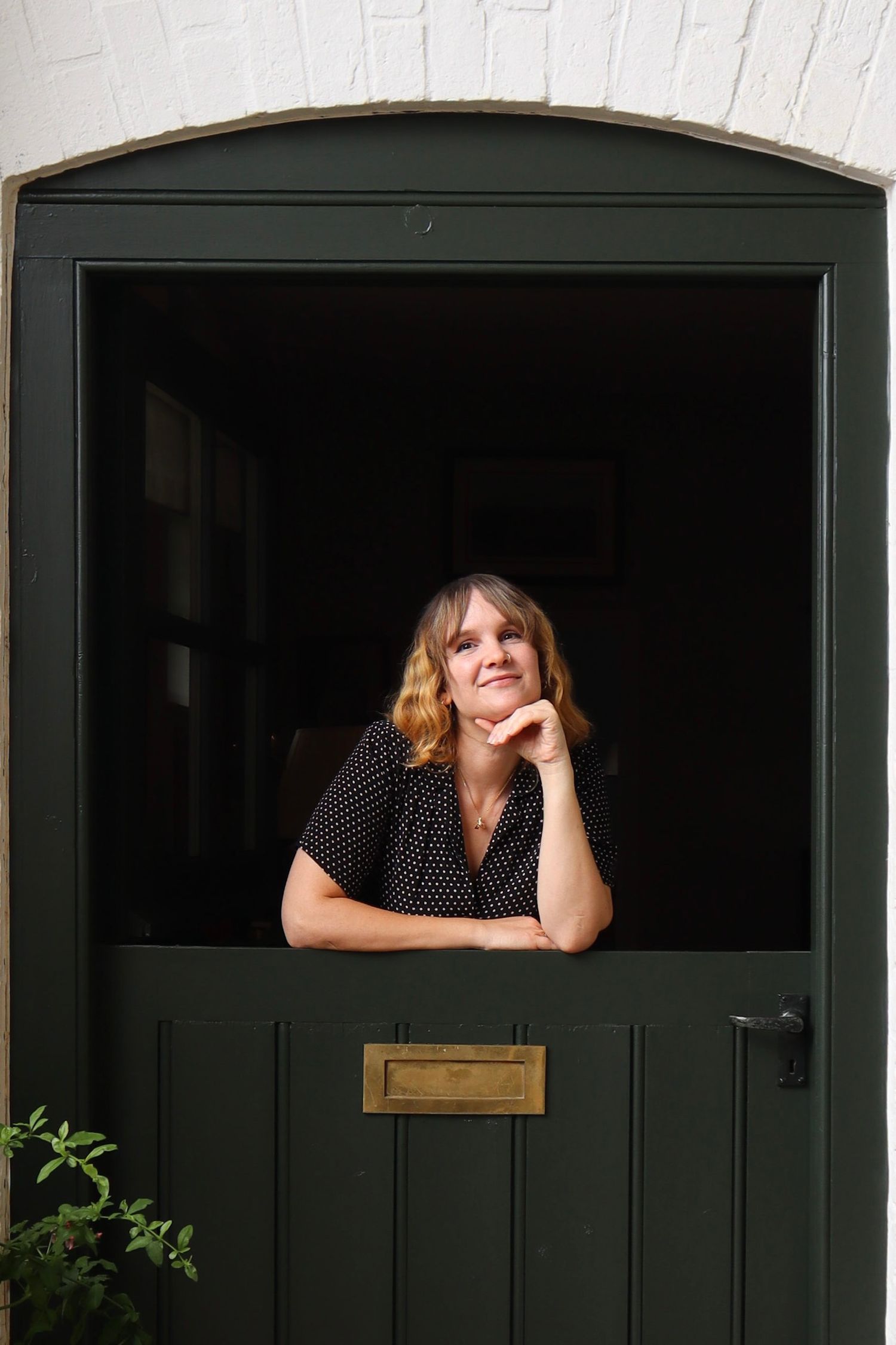 a portrait of a woman posing inside a doorway