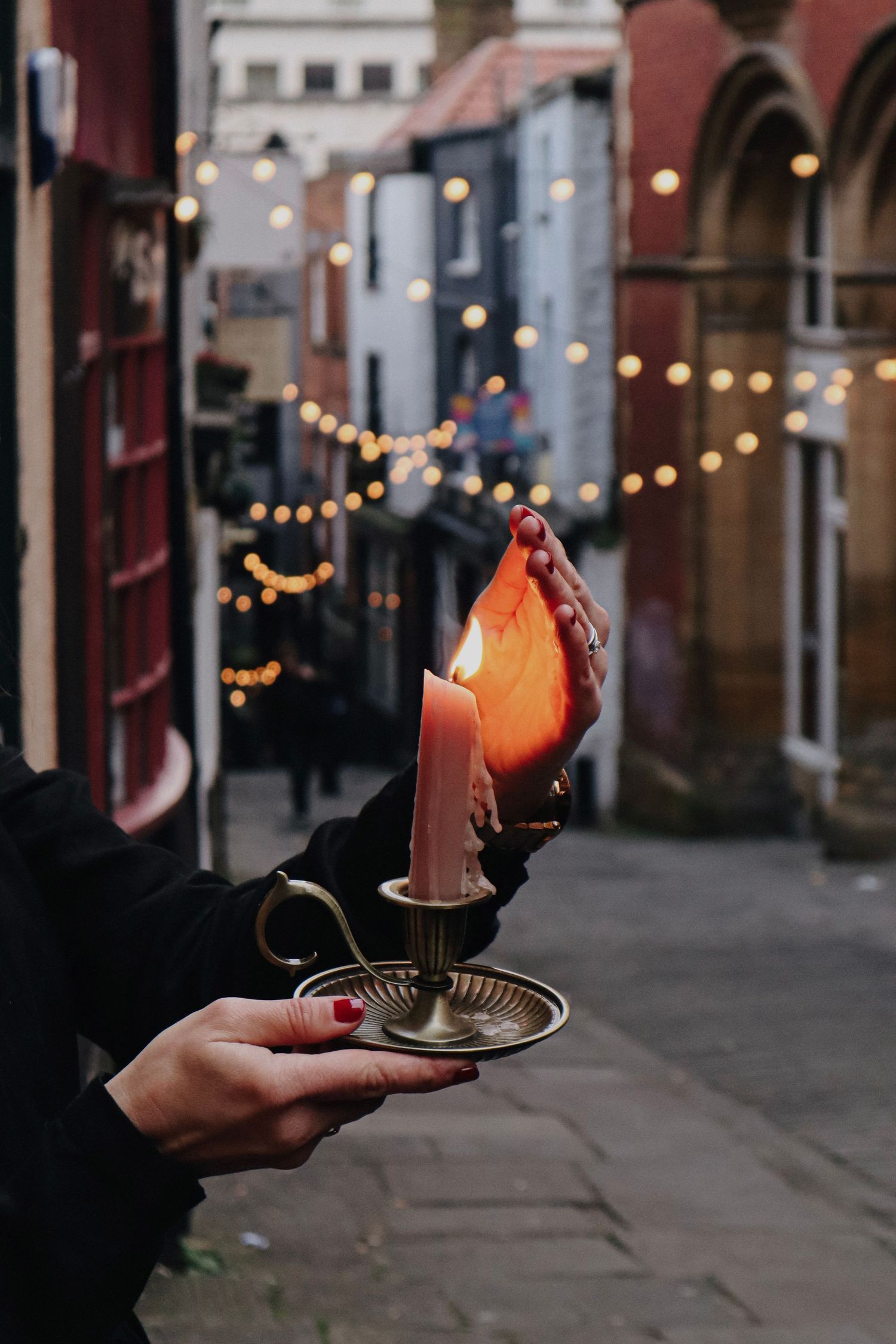 A woman holds a burning candle on the Christmas Steps in Bristol