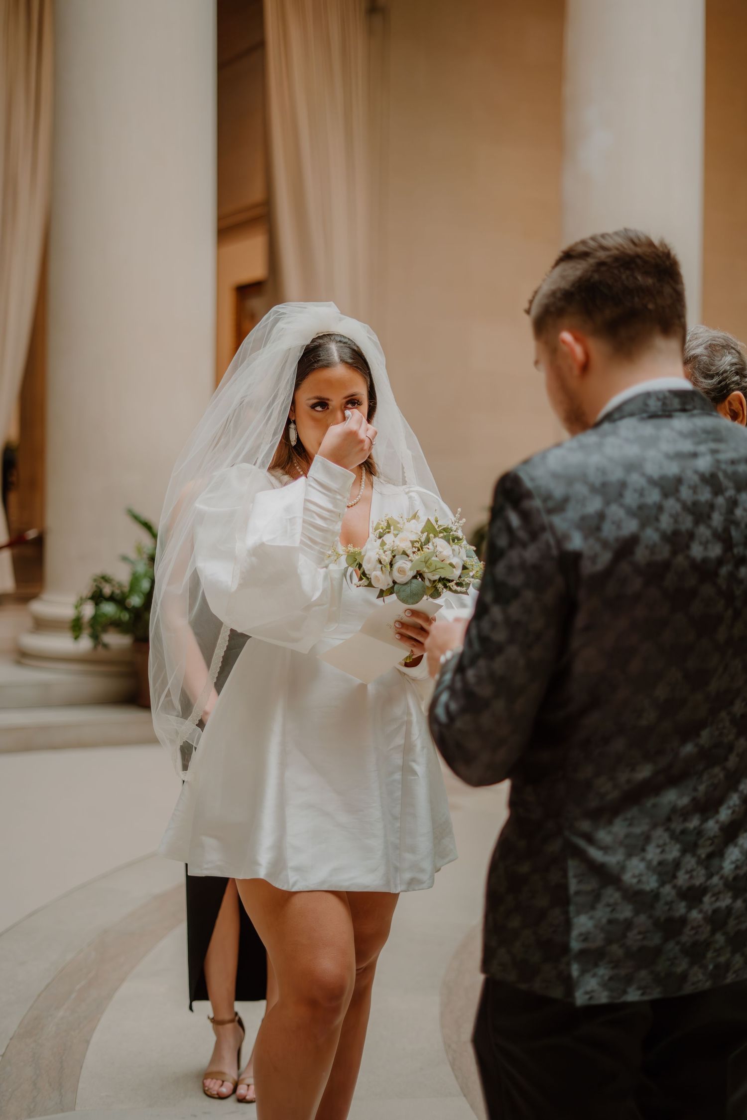 Bride wiping tears as groom reads vows at the National Gallery of Art in Washington DC