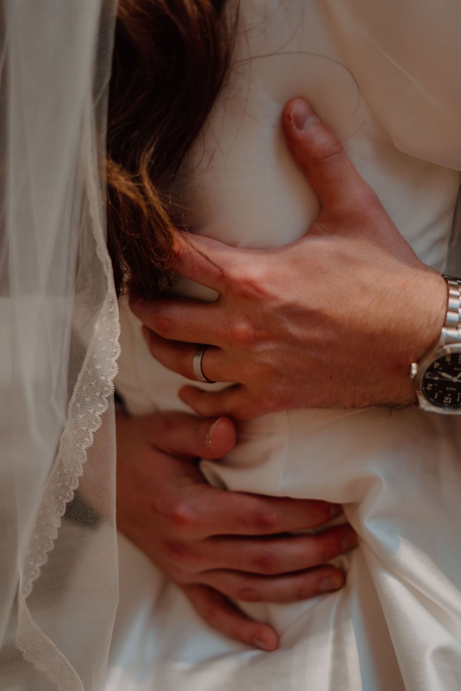 Detail shot of grooms ring while he hugs his bride at the National Gallery of Art in Washington DC