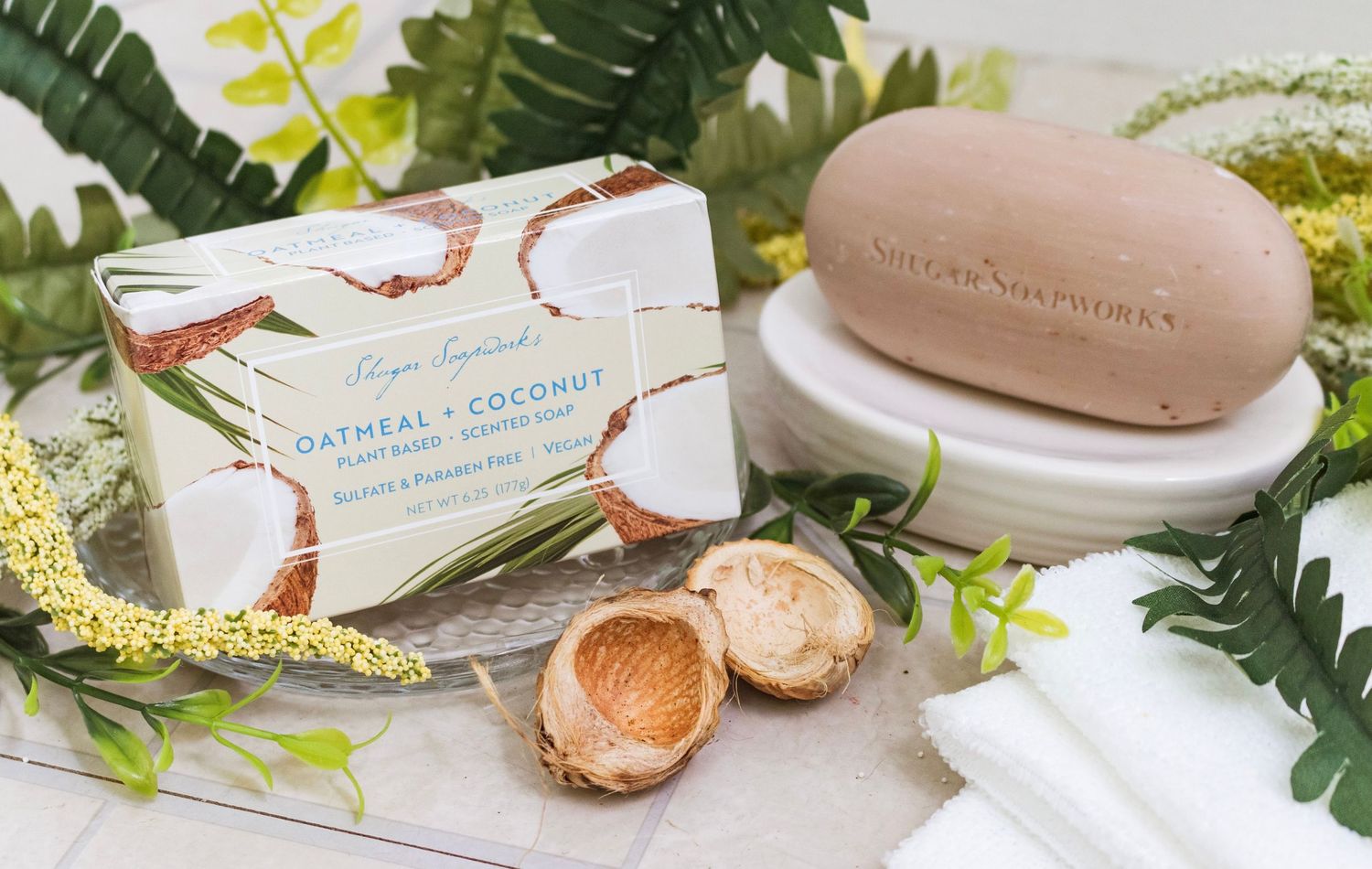 Natural soap and skincare products displayed with ferns and botanical elements.