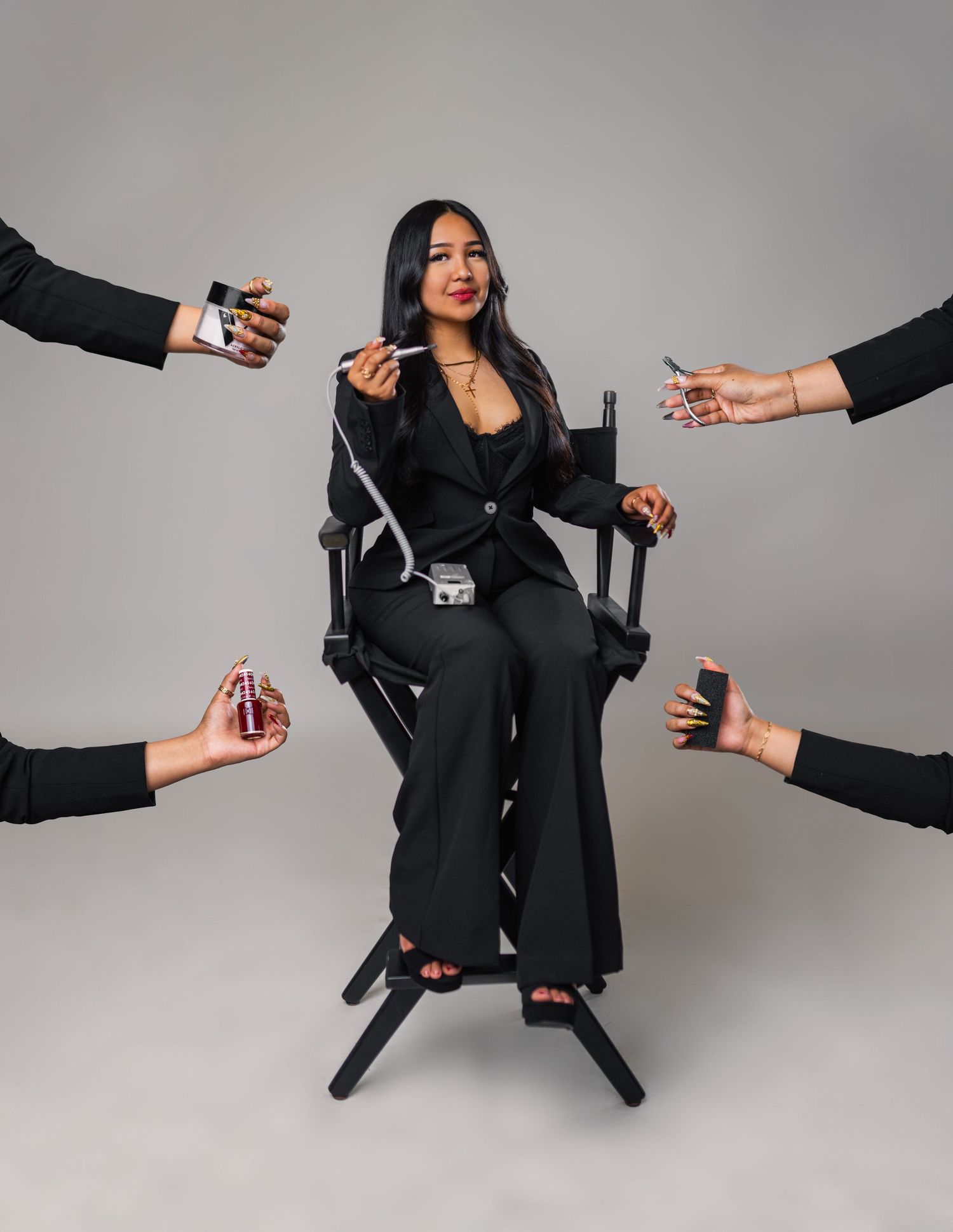 Woman in black blazer sitting in office chair being offered multiple hot beverages from hands reaching into frame.