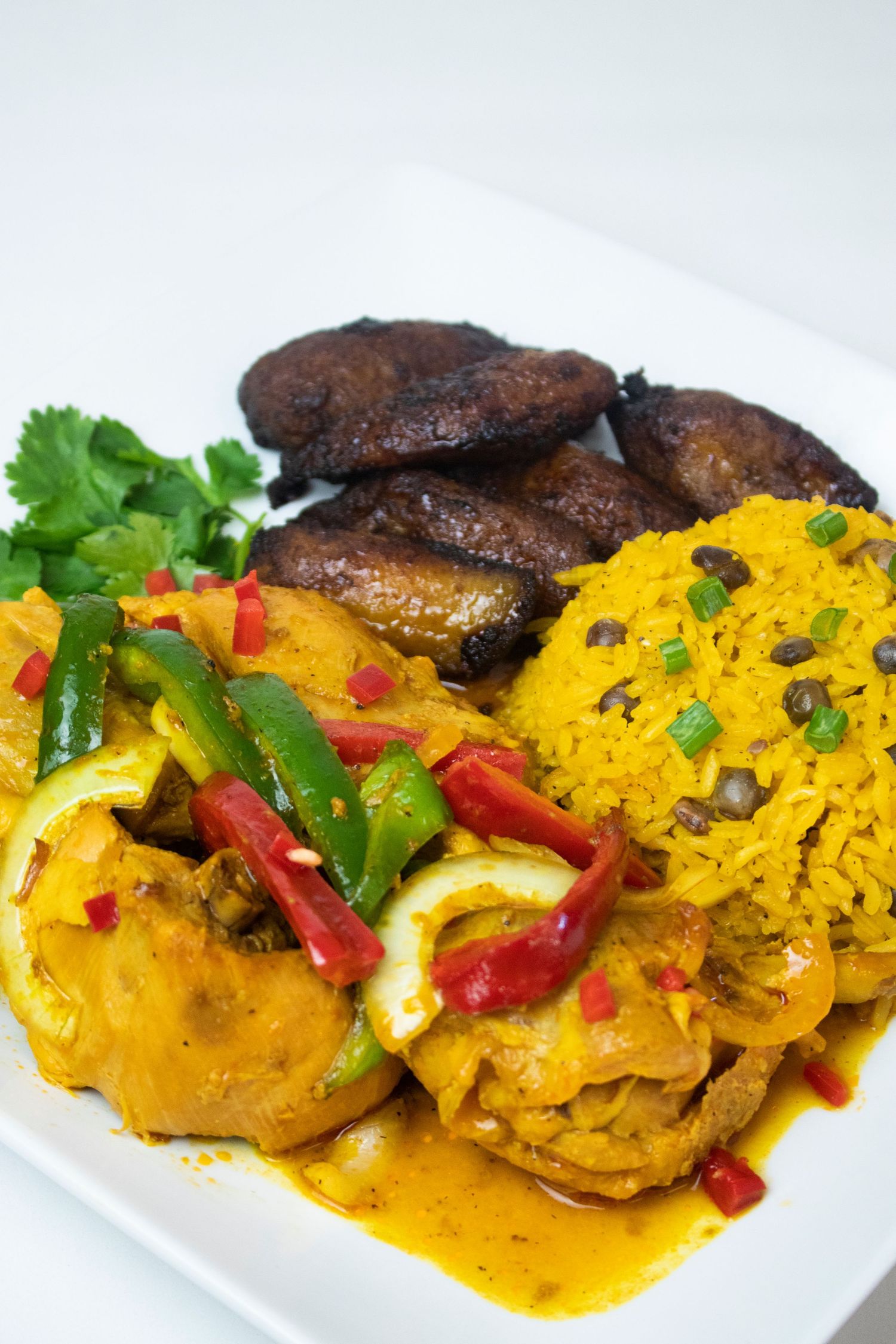 Spicy curry chicken with mushrooms and colorful bell peppers garnished with fresh herbs.