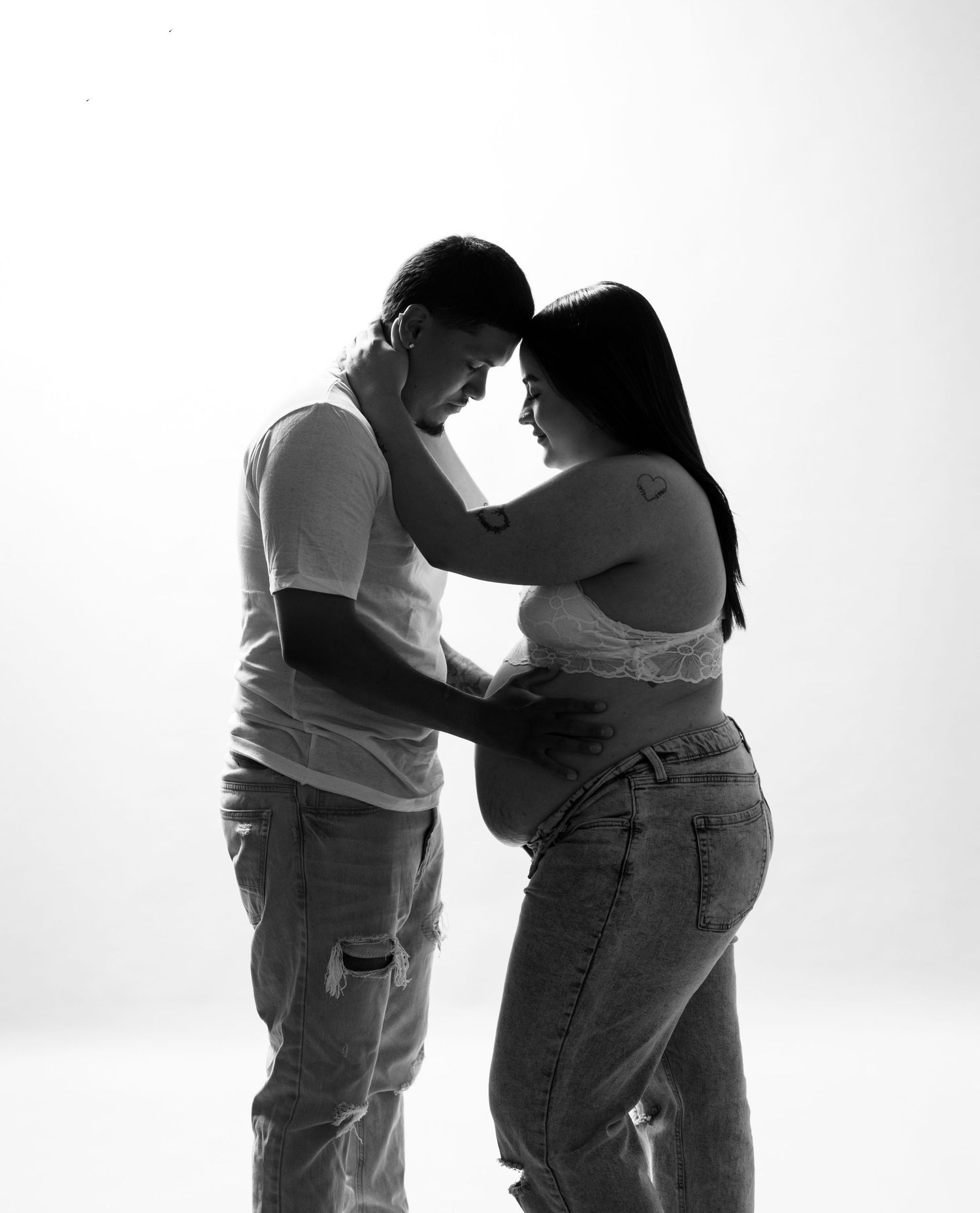 Intimate black and white portrait of a couple in tender embrace.