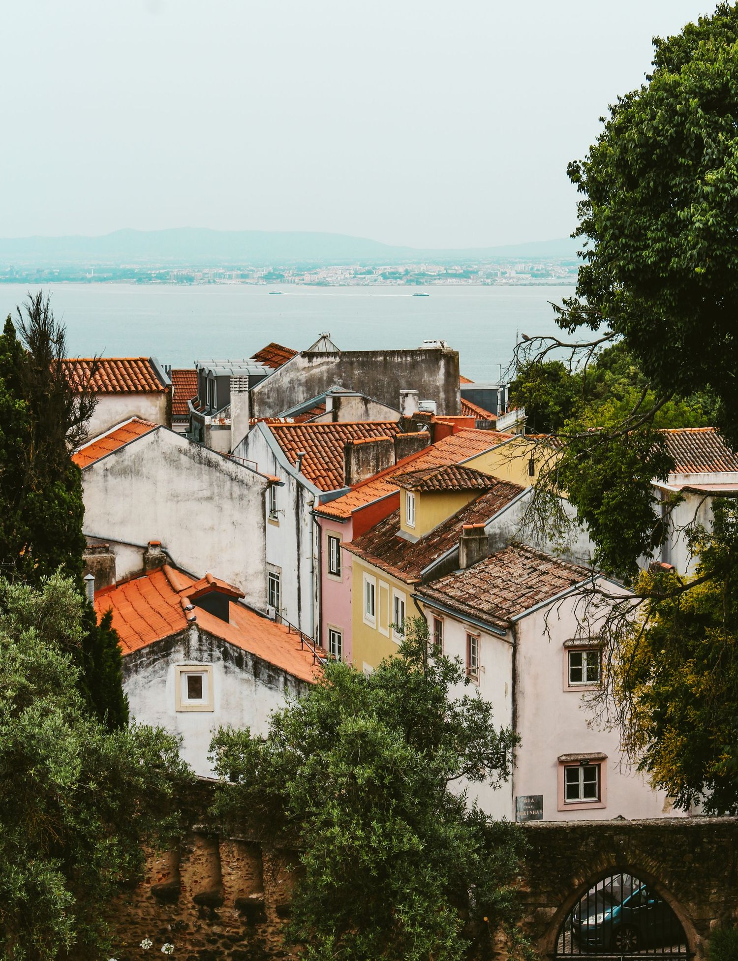 Coastal village with terracotta roofs and whitewashed buildings overlooking blue waters.