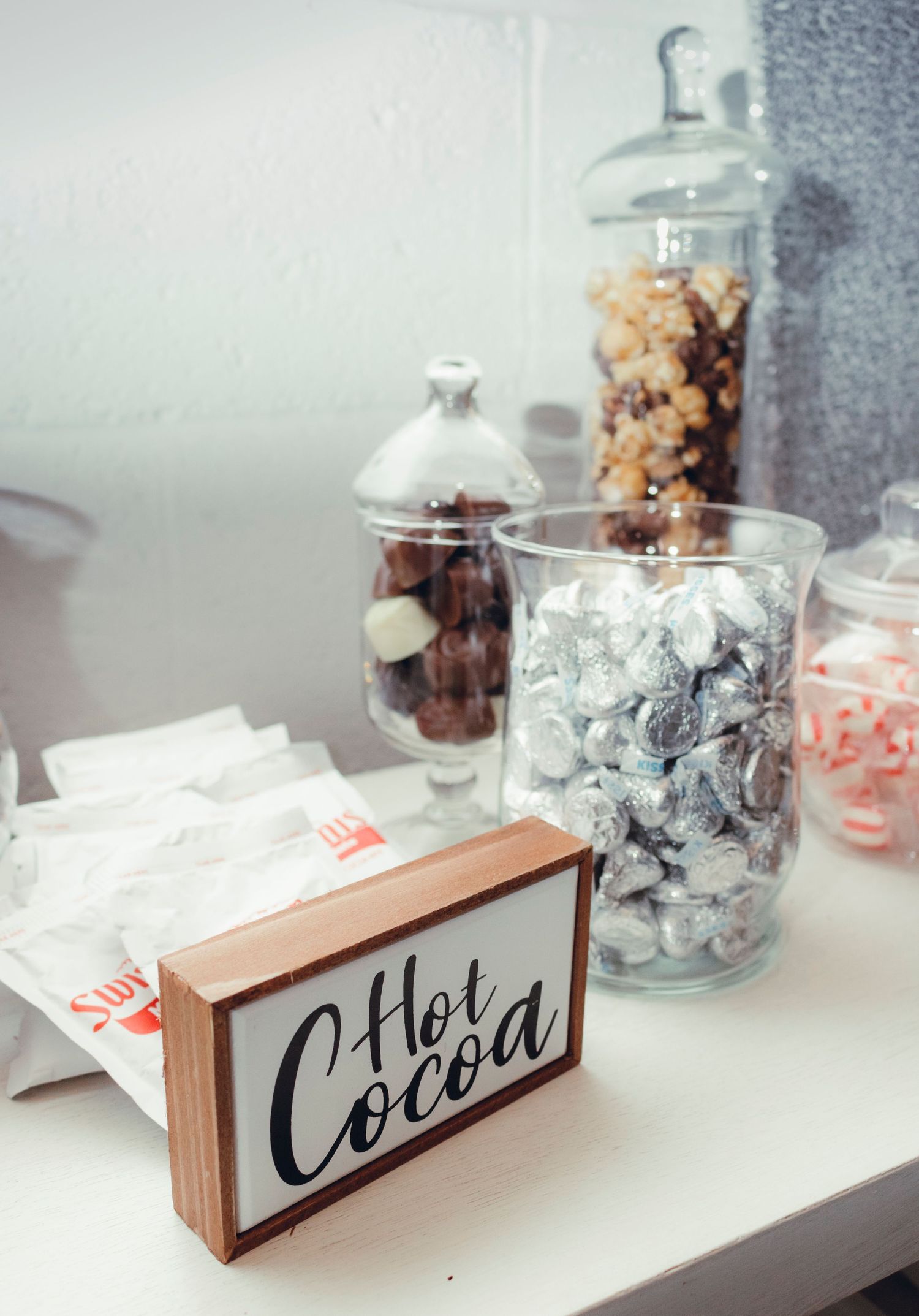 Collection of clear glass jars displaying modern black and wood signage arranged on a white surface in a minimalist style.
