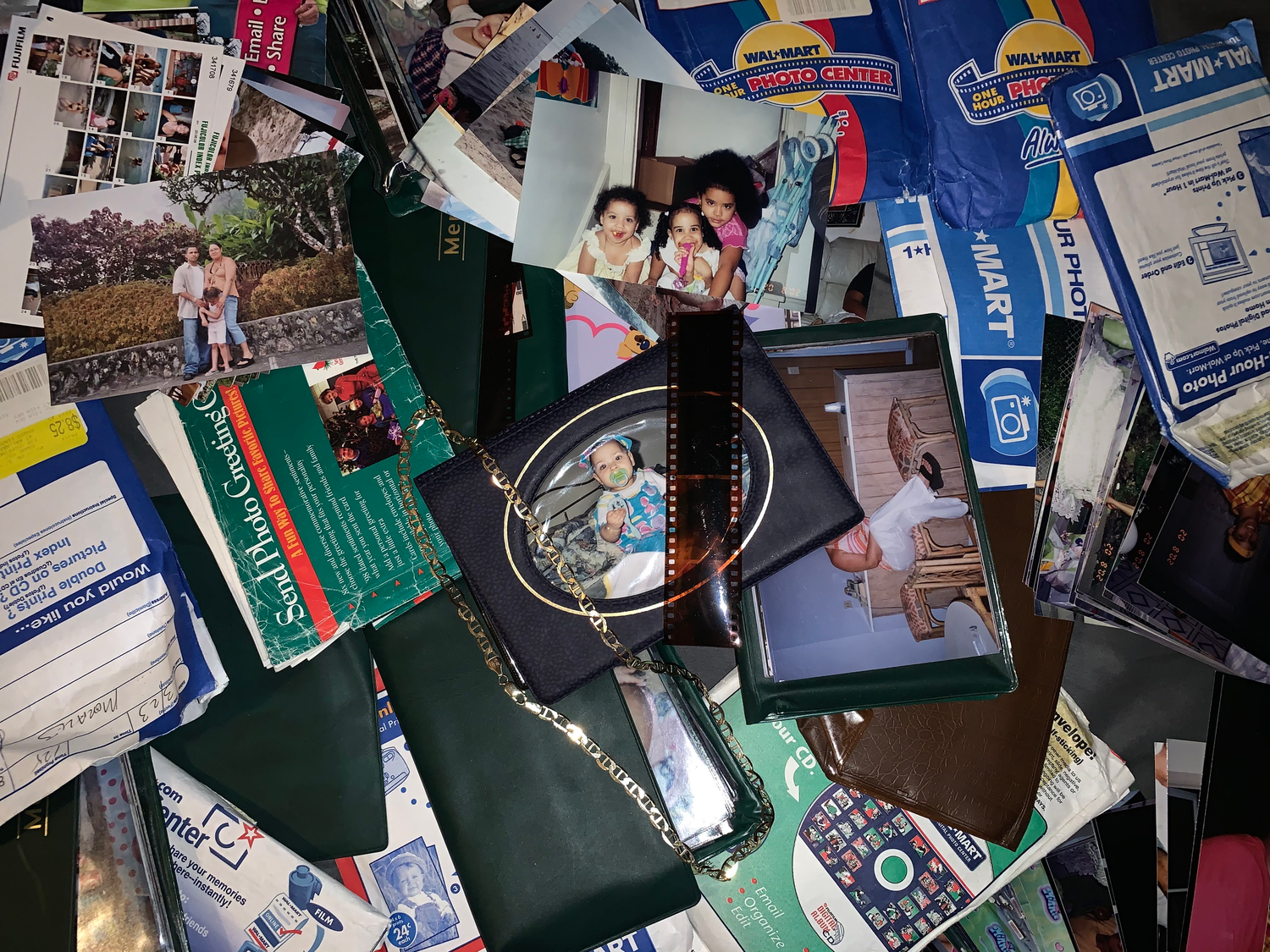 Messy collection of vintage photographs and memorabilia scattered on surface.
