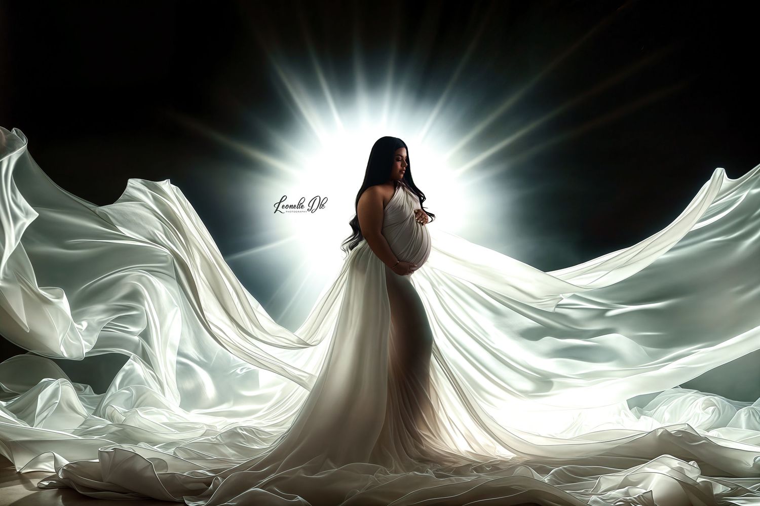 A flowing white wedding veil dramatically billows in a dark studio with dramatic backlighting creating an ethereal effect.