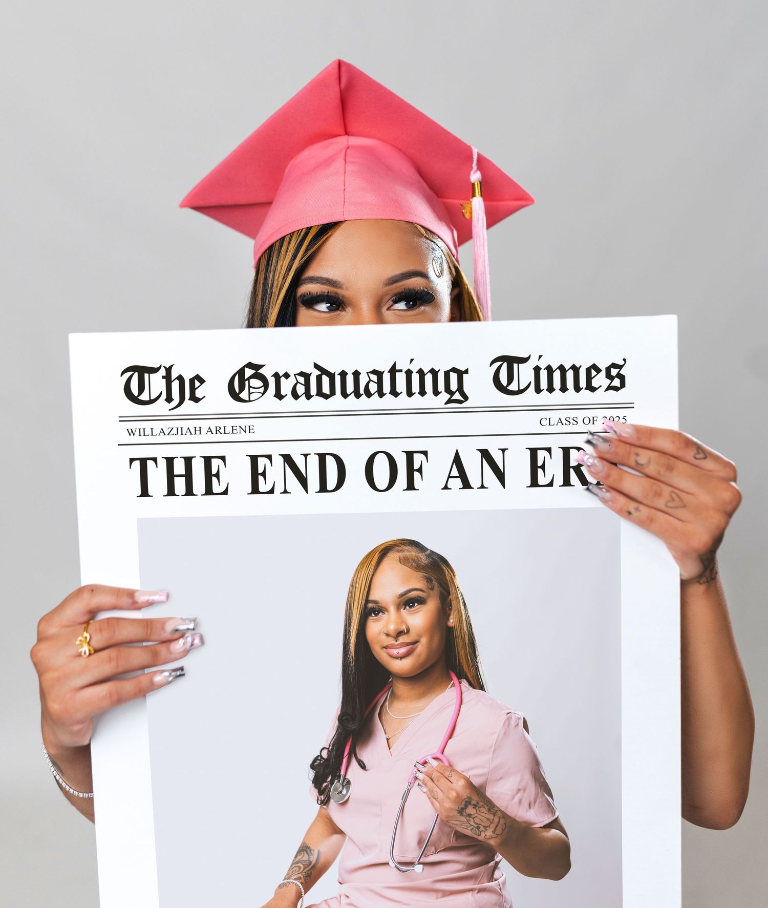 Graduate in pink cap and gown holds up a newspaper with 'The Graduating Times' headline for a creative photo shoot.