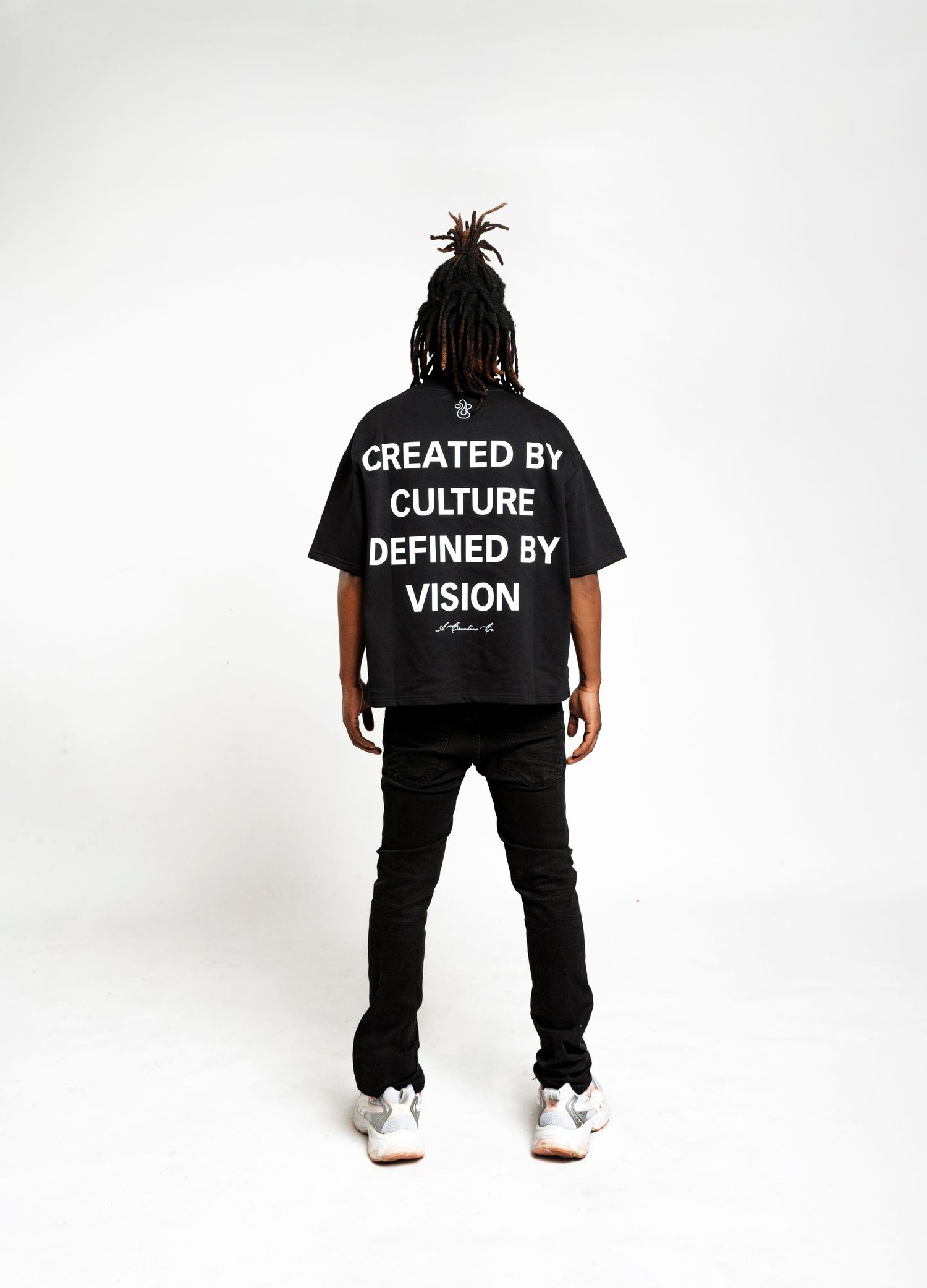 Back view of black t-shirt with 'Created by Culture Defined by Vision' text in white letters.