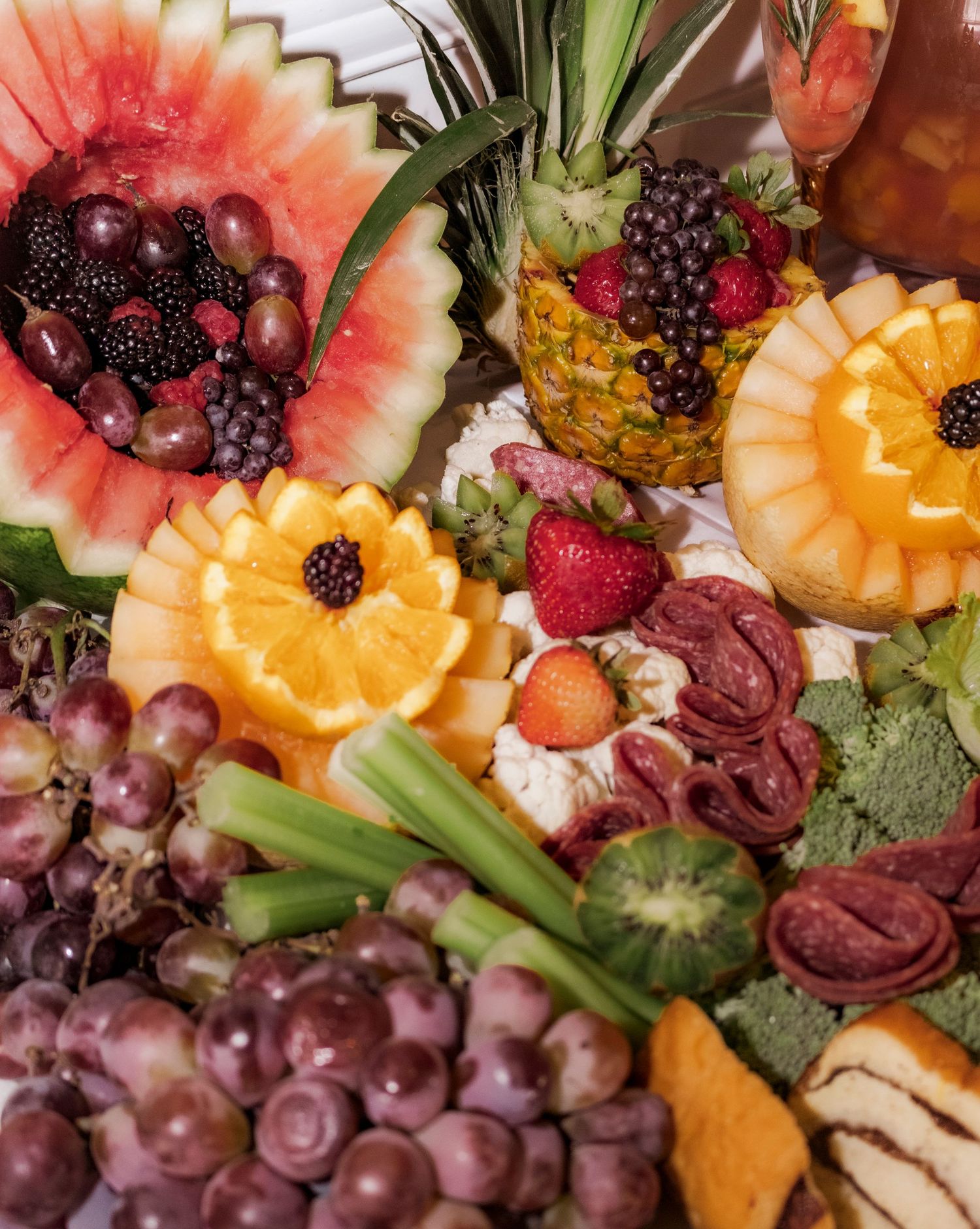 Colorful fruit platter with watermelon, pineapple, berries and grapes artfully arranged.