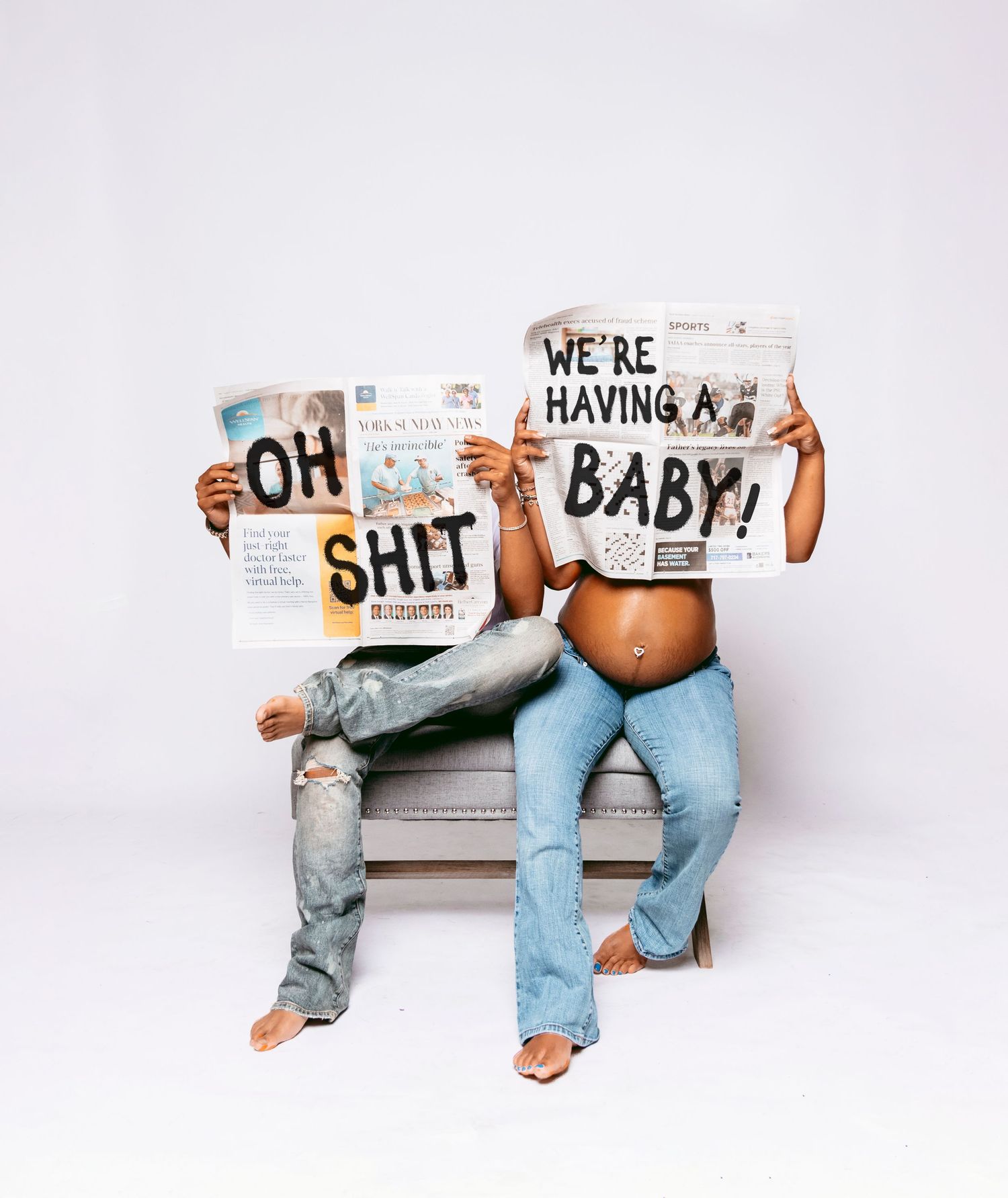 Creative pregnancy announcement photo with couple holding humorous signs while sitting on bench.