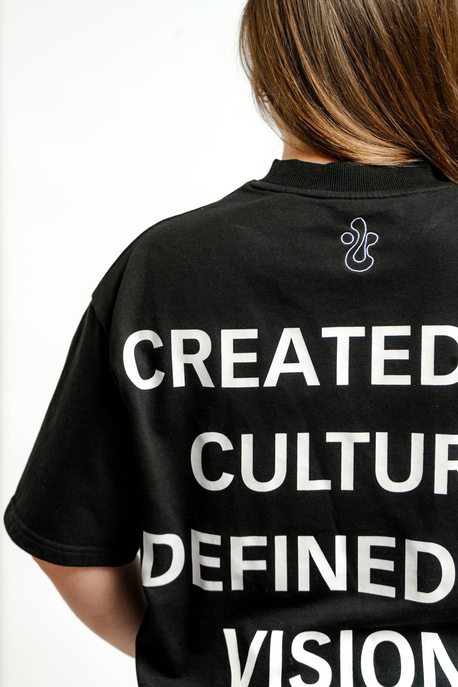 Back view of black t-shirt with white text reading 'Created Culture Defined Vision'.