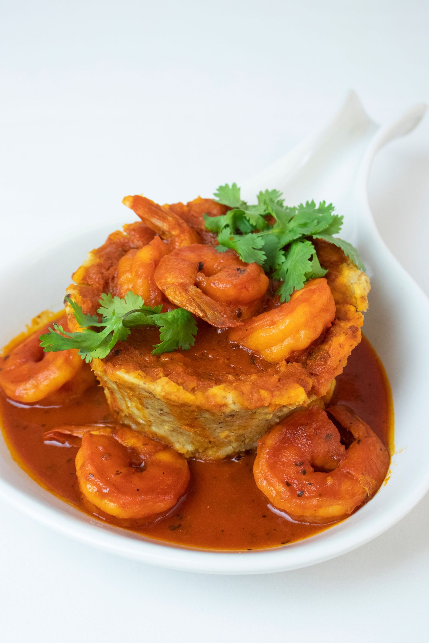Spicy shrimp in red sauce served over a cornmeal cake and garnished with fresh cilantro.