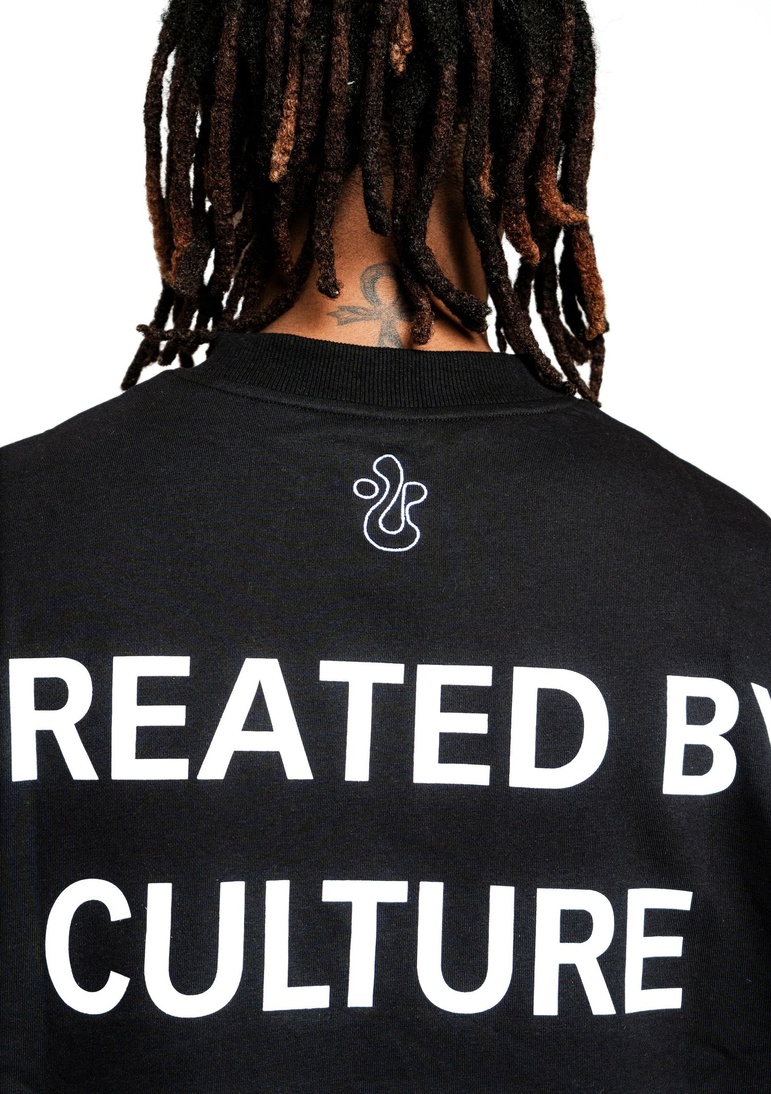 Close-up of black t-shirt back showing 'Created by Culture' text and logo detail.