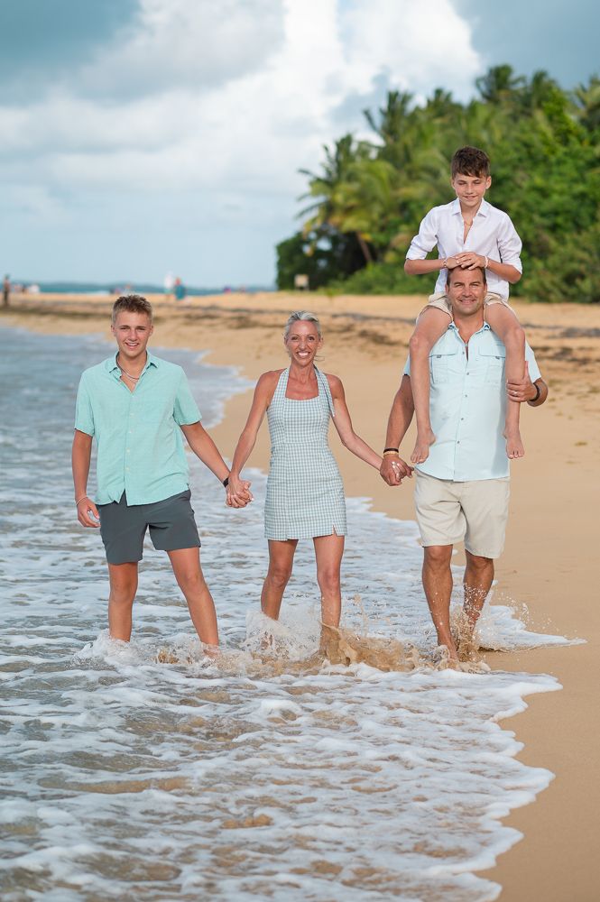 arents playing with children in shallow ocean water at Playa Azul beach in Luquillo Puerto Rico