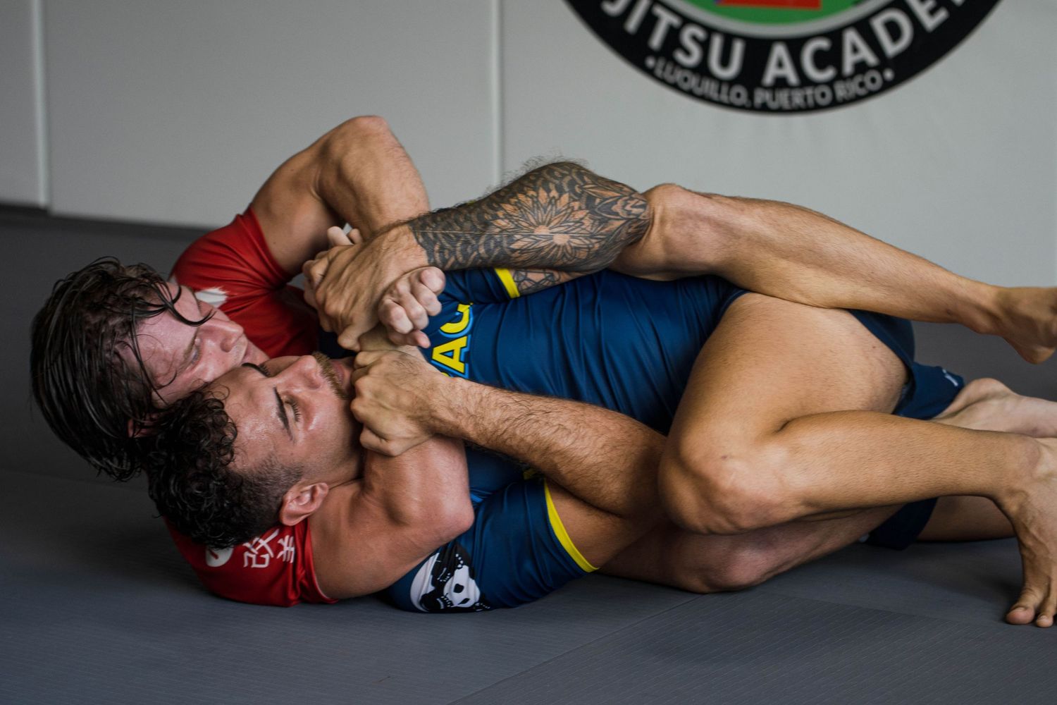 Two athletes sparring in Brazilian Jiu Jitsu training at Costa Este gym in Luquillo”