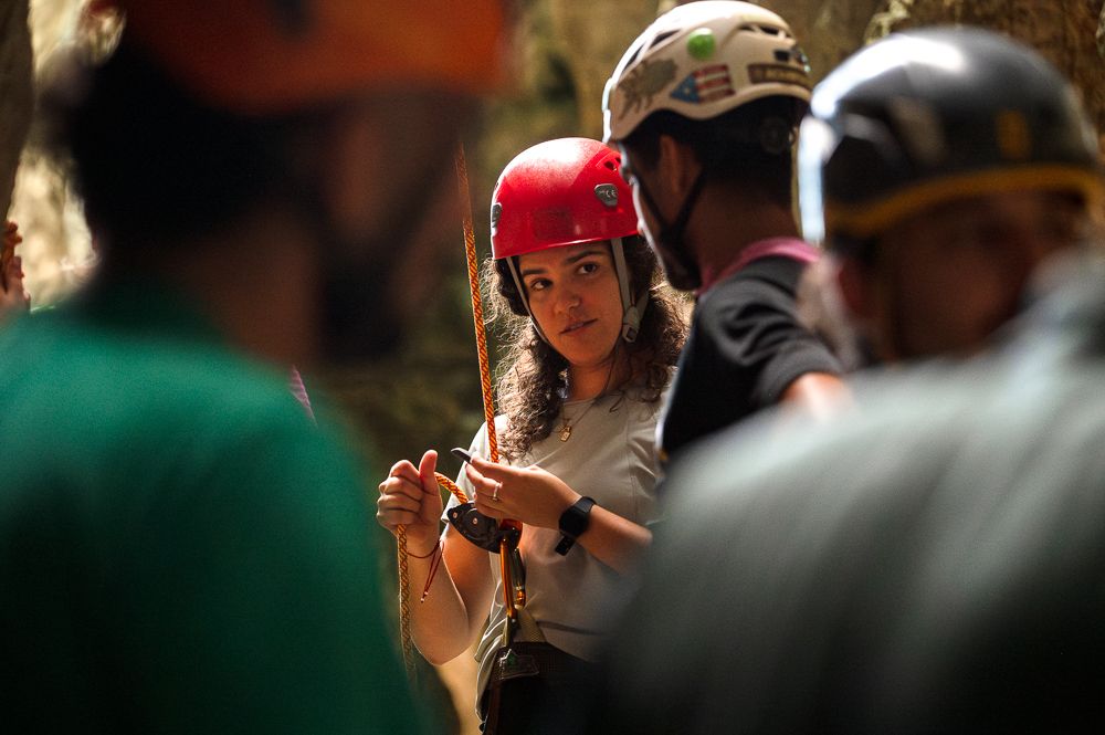 Female climber preparing safety gear during rock climbing event with PRSOAR in Monagas Park