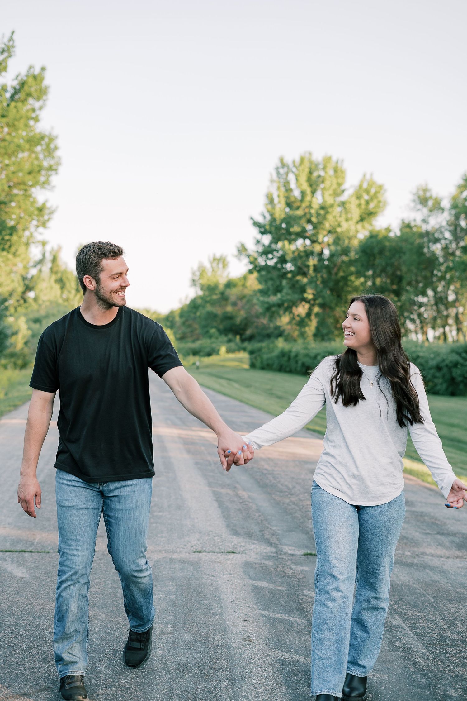 Couple holding hands while walking down a rural road.