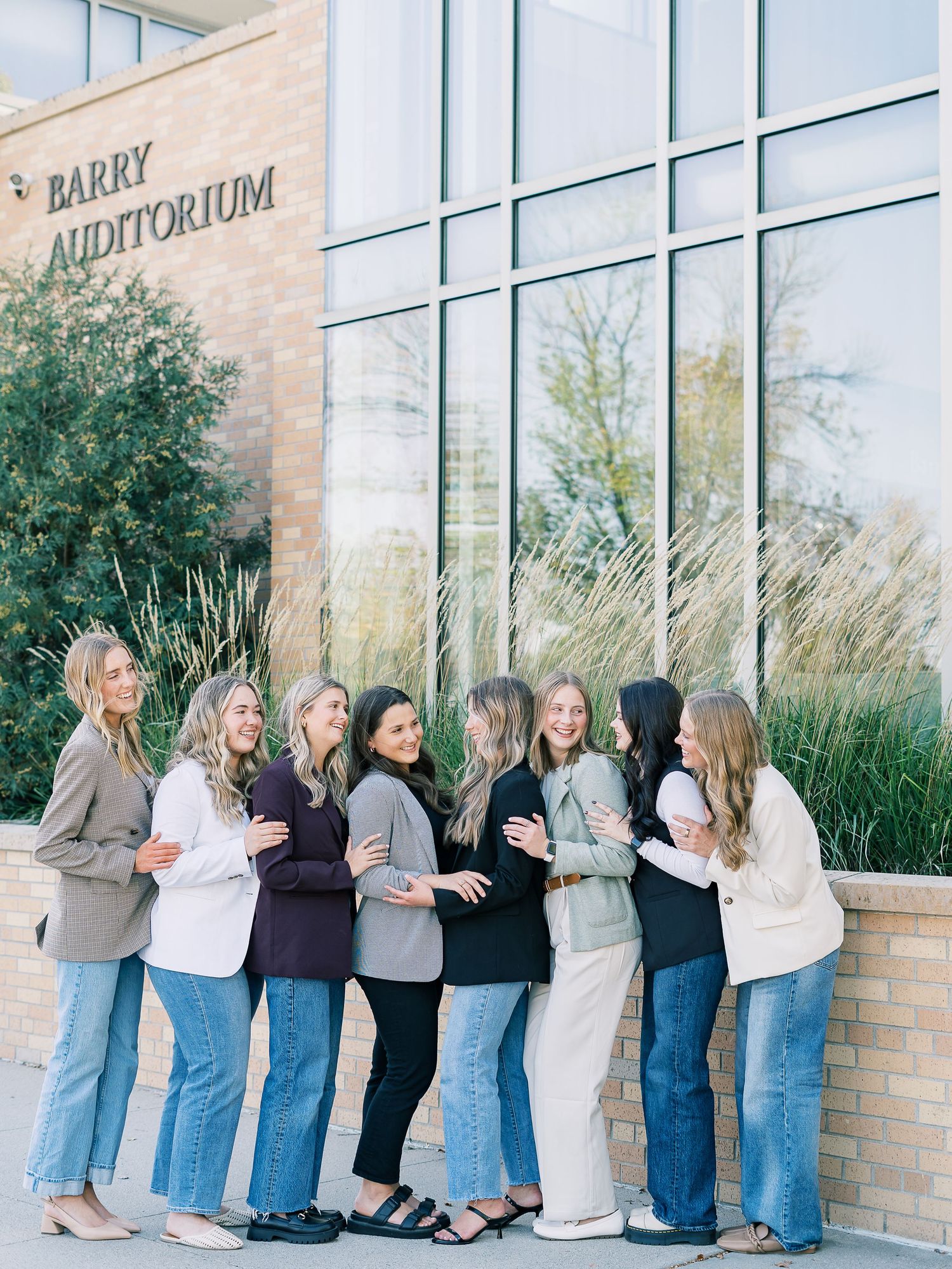 A creative panoramic photo sequence showing a group in blue jeans lined up against a brick building wall.