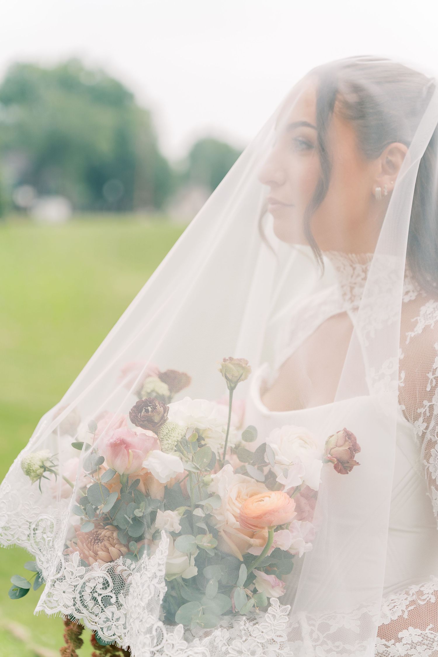 A romantic bridal portrait series showing a delicate veil and peach and white floral bouquet in an outdoor setting.