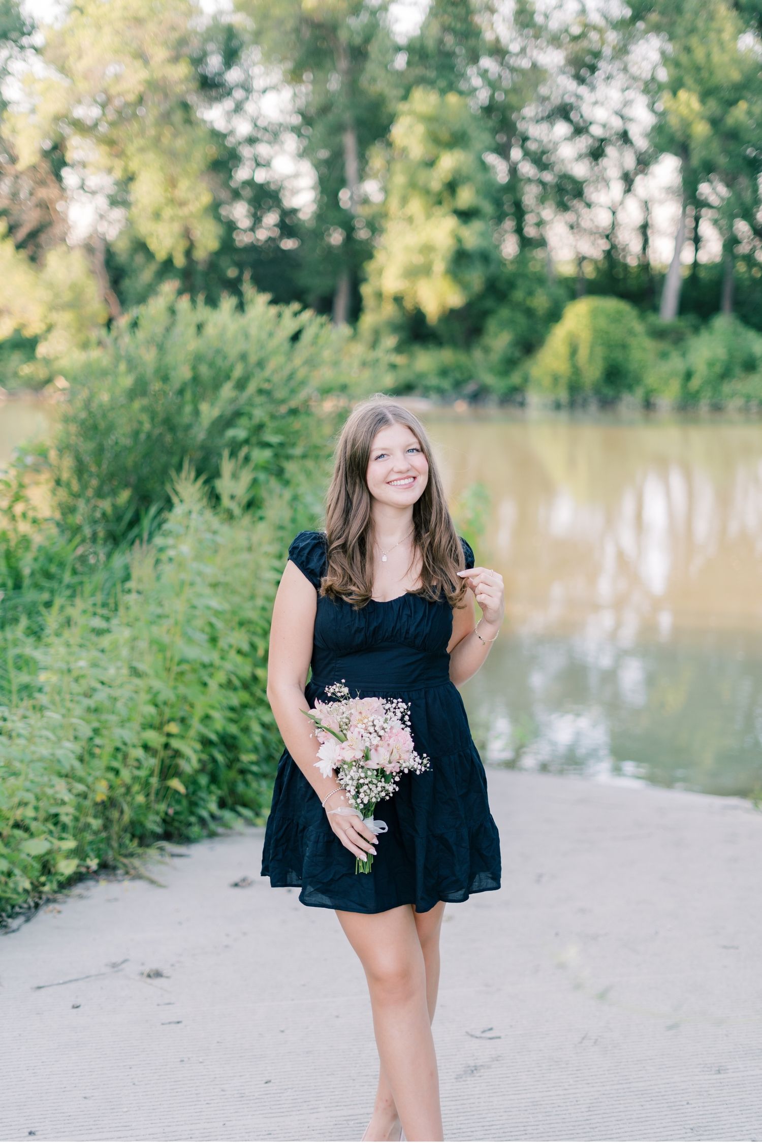 A series of outdoor portraits on a sandy beach near a lake with lush greenery in the background.