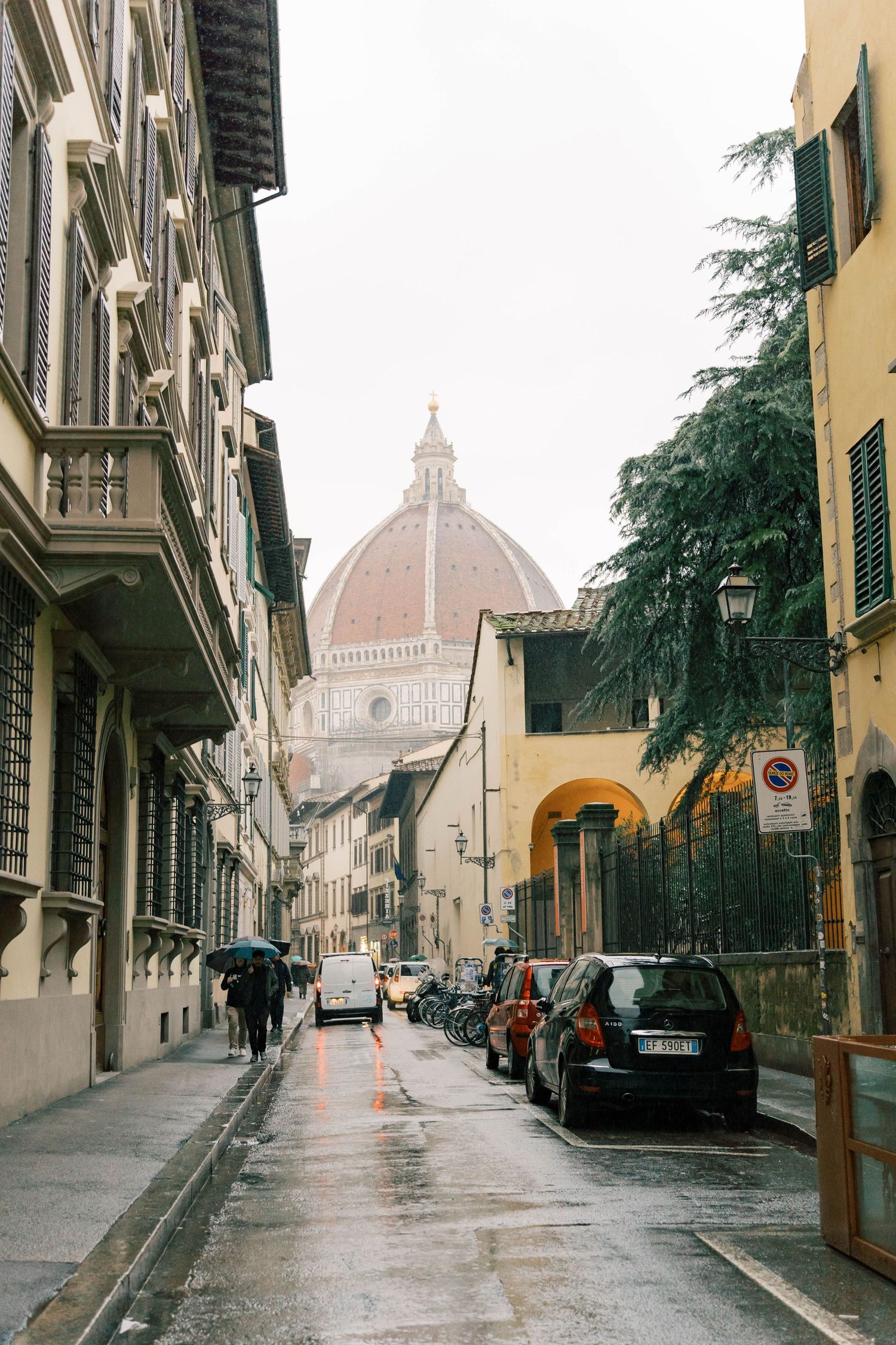 Historic street view of Florence with the Duomo cathedral dome visible in the distance.