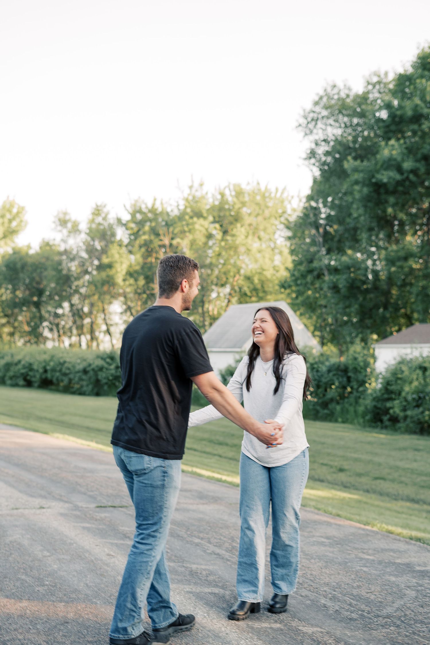Couple sharing a candid moment on a country road during golden hour.