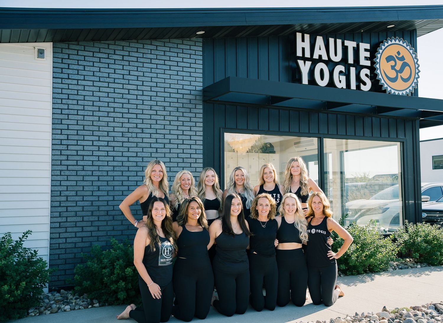 A group of women in black outfits pose together outside a brick building in a series of celebratory photos.