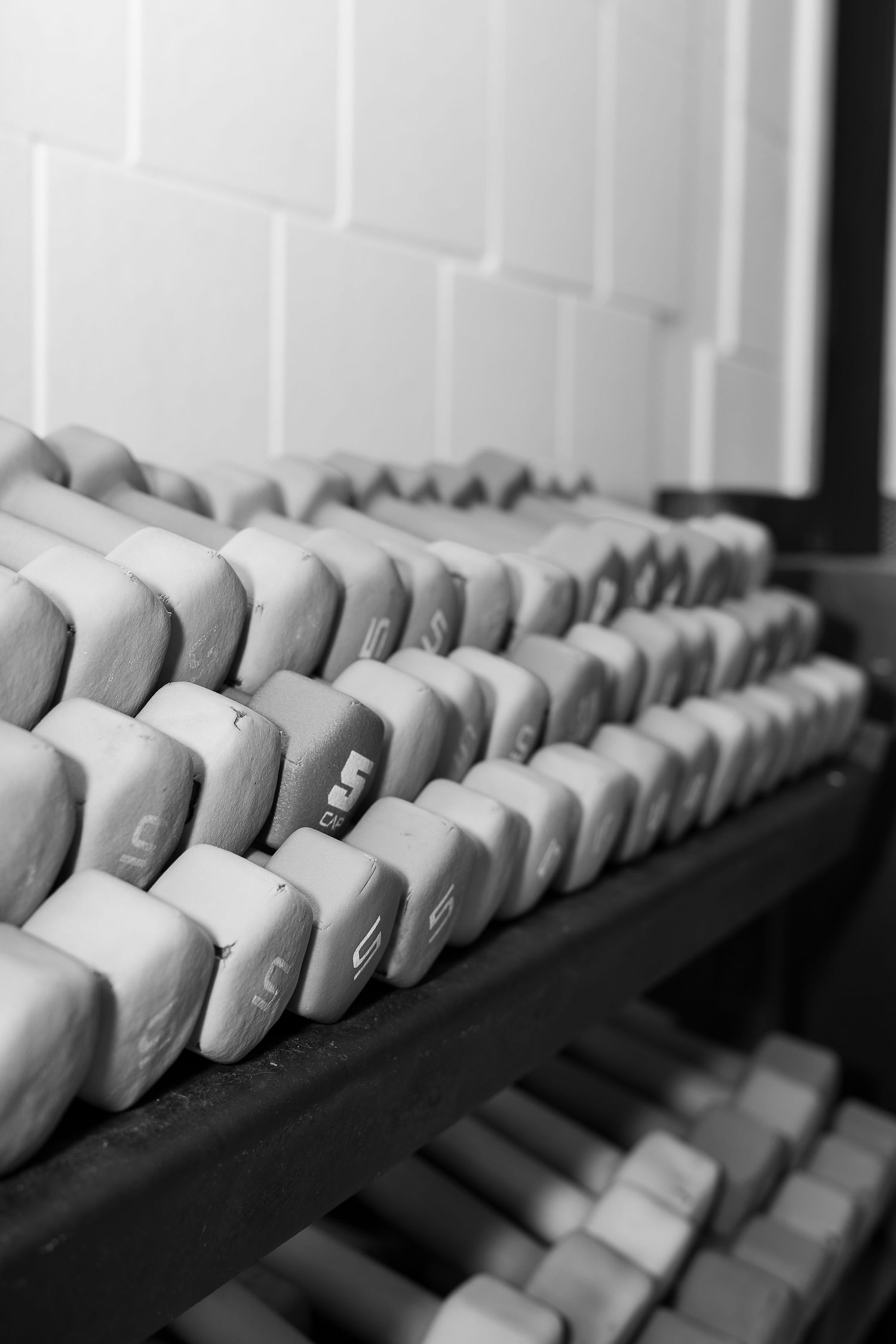 Black and white photo of piano keys in a repeating diagonal pattern creating a minimalist abstract composition.