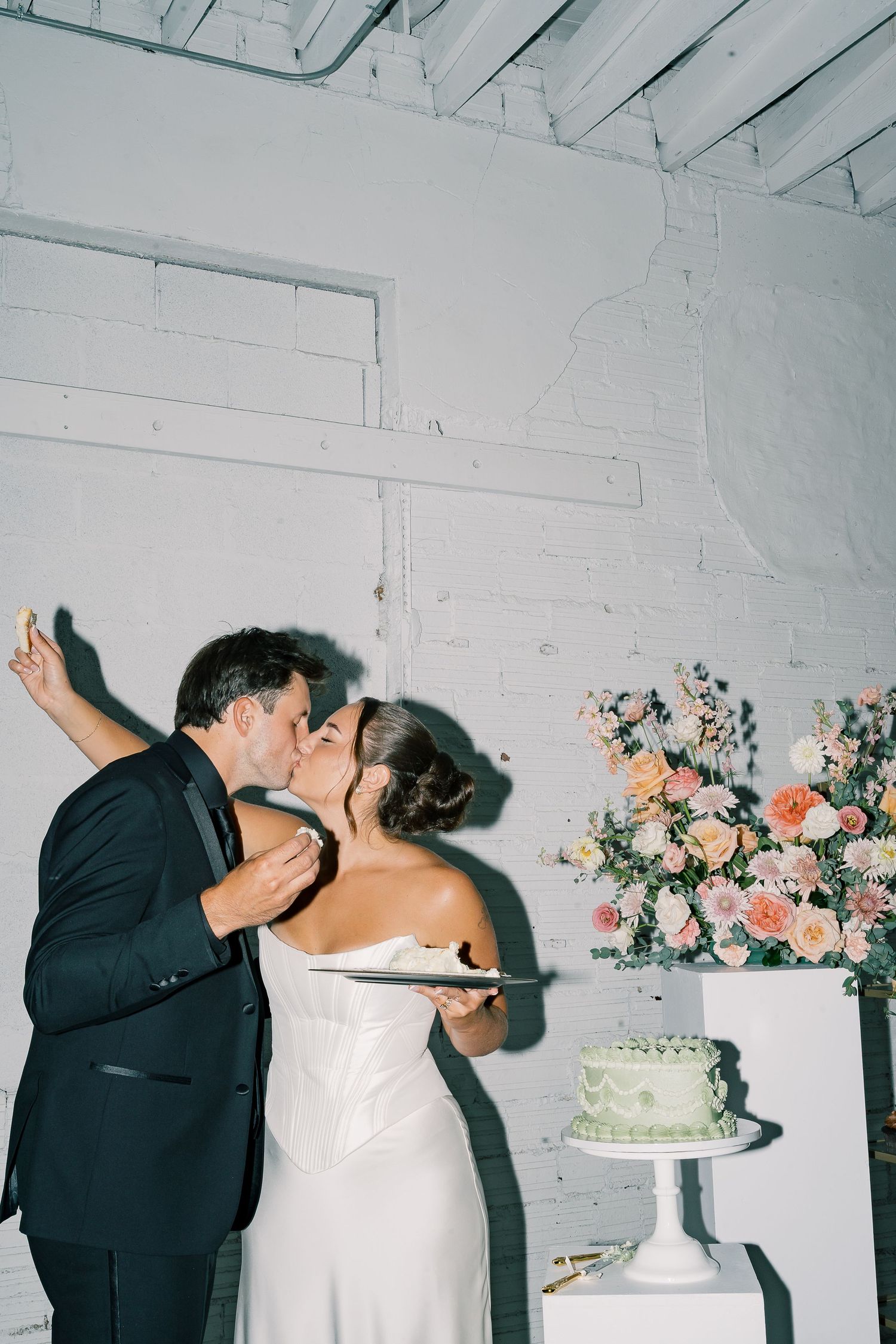 A sequence of wedding cake smashing photos showing a couple playfully smearing frosting on each other at their reception.