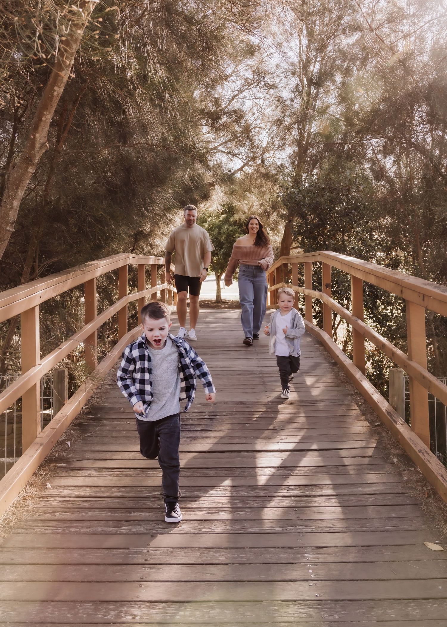 A sequence of action shots showing movement across a wooden footbridge in a wooded park setting.