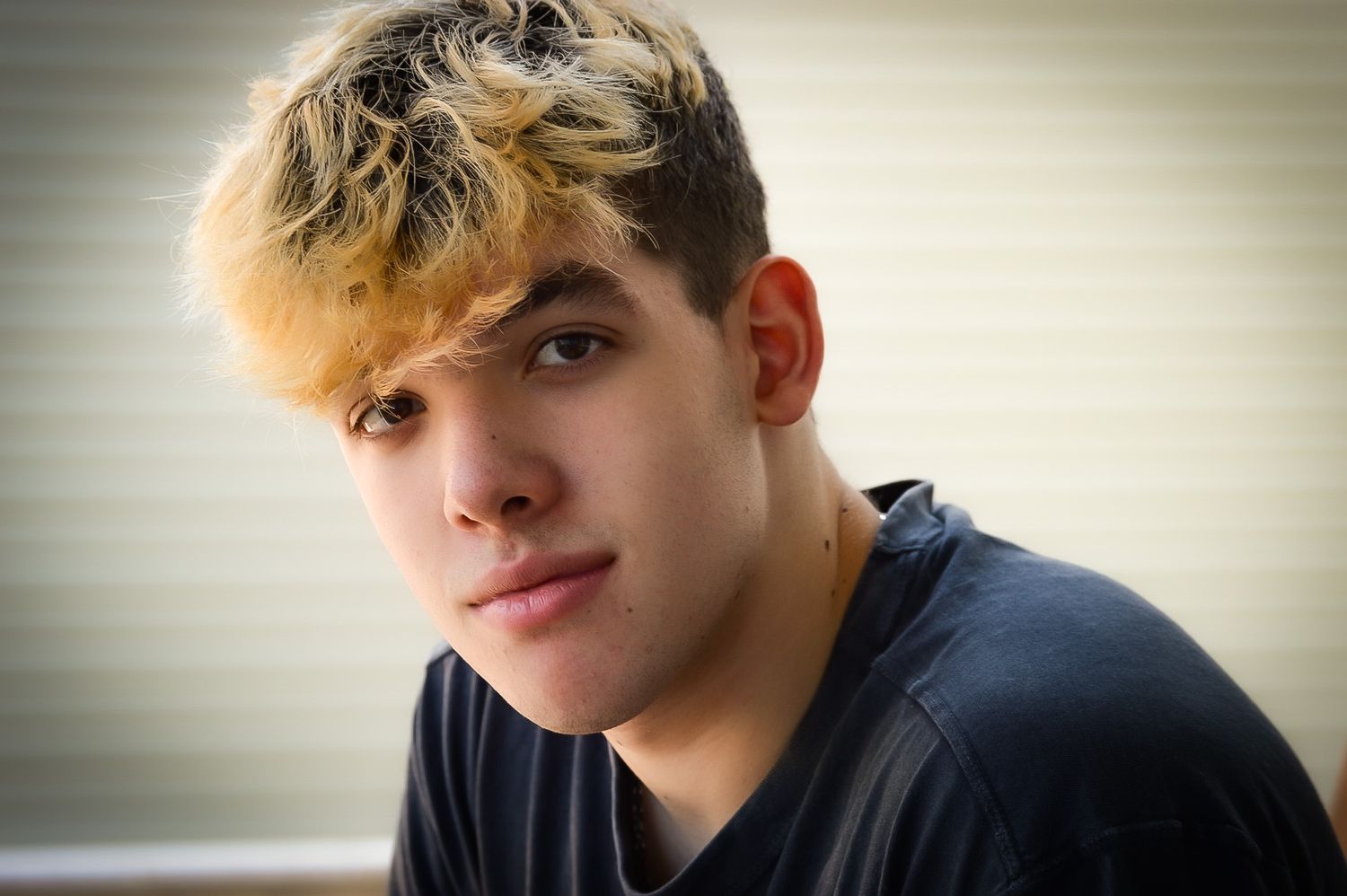 Portrait of young person in casual attire against neutral background.
