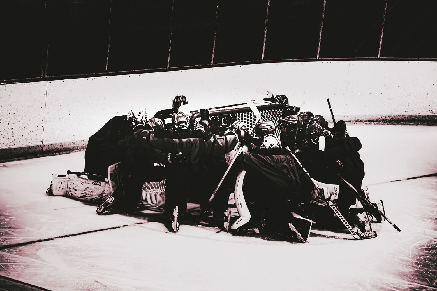 Black and white photo of hockey players praying before game