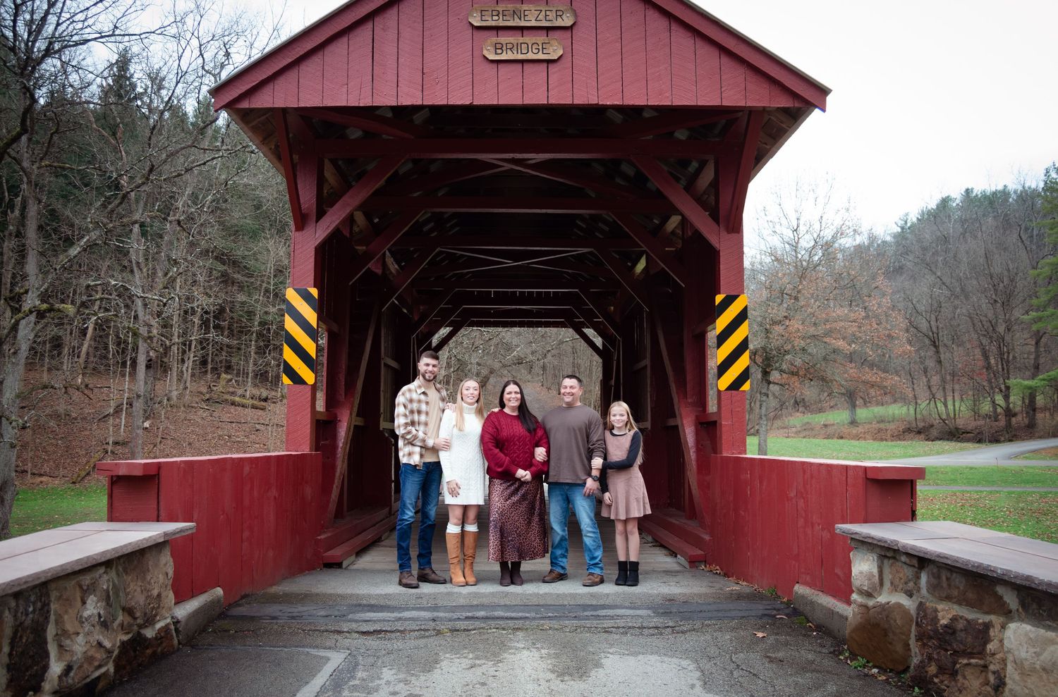 A series of red covered bridges in rural settings showing different architectural angles and perspectives.