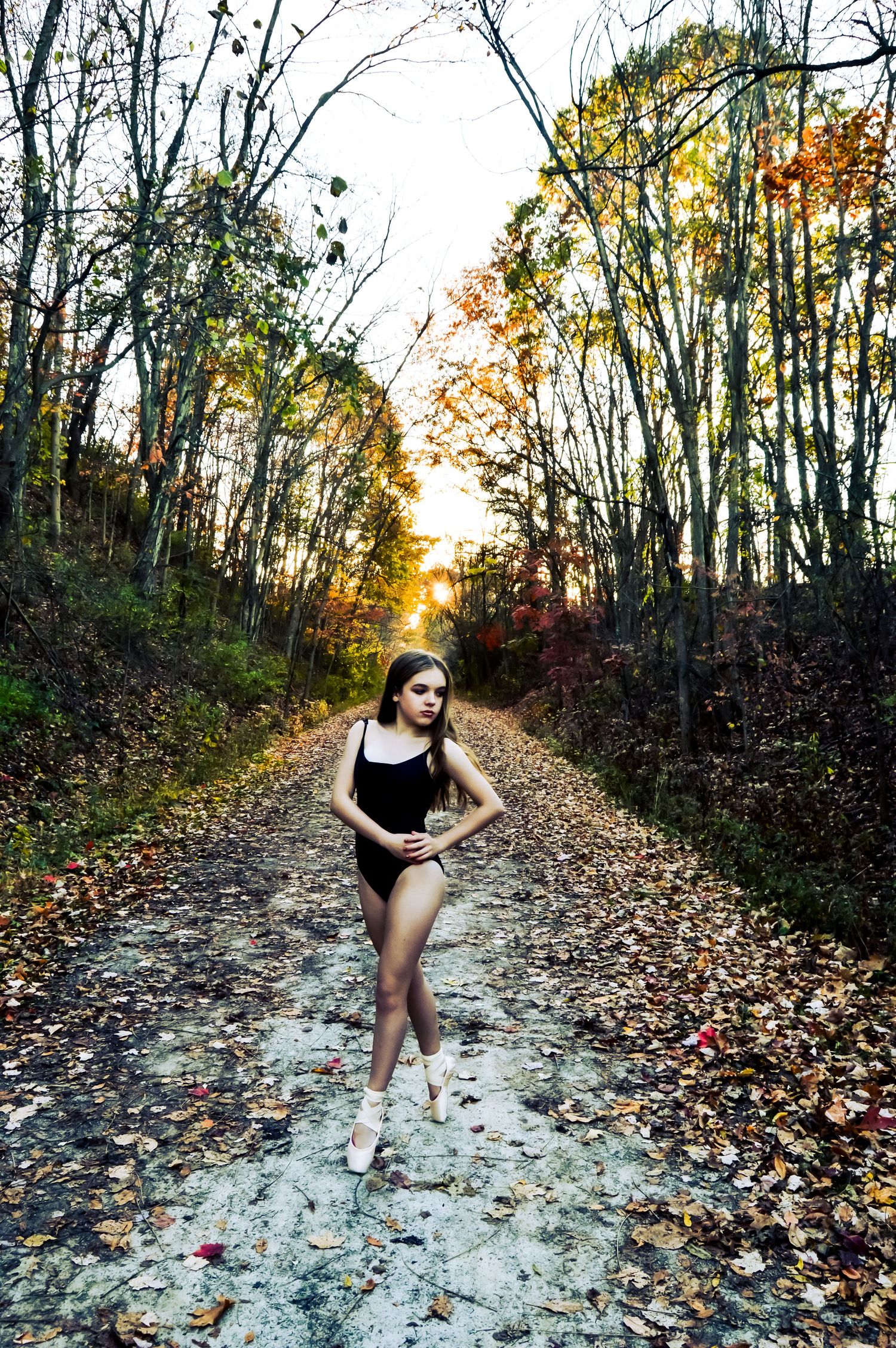Dance photo series on an autumn trail with dramatic golden hour lighting.