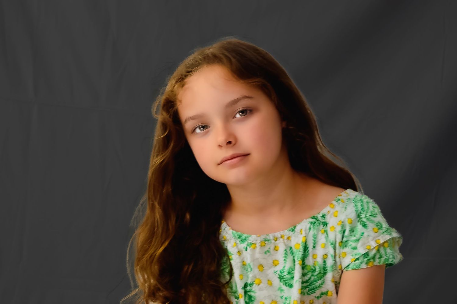 A series of four black and white studio portraits with a person wearing a floral dress against a dark background.