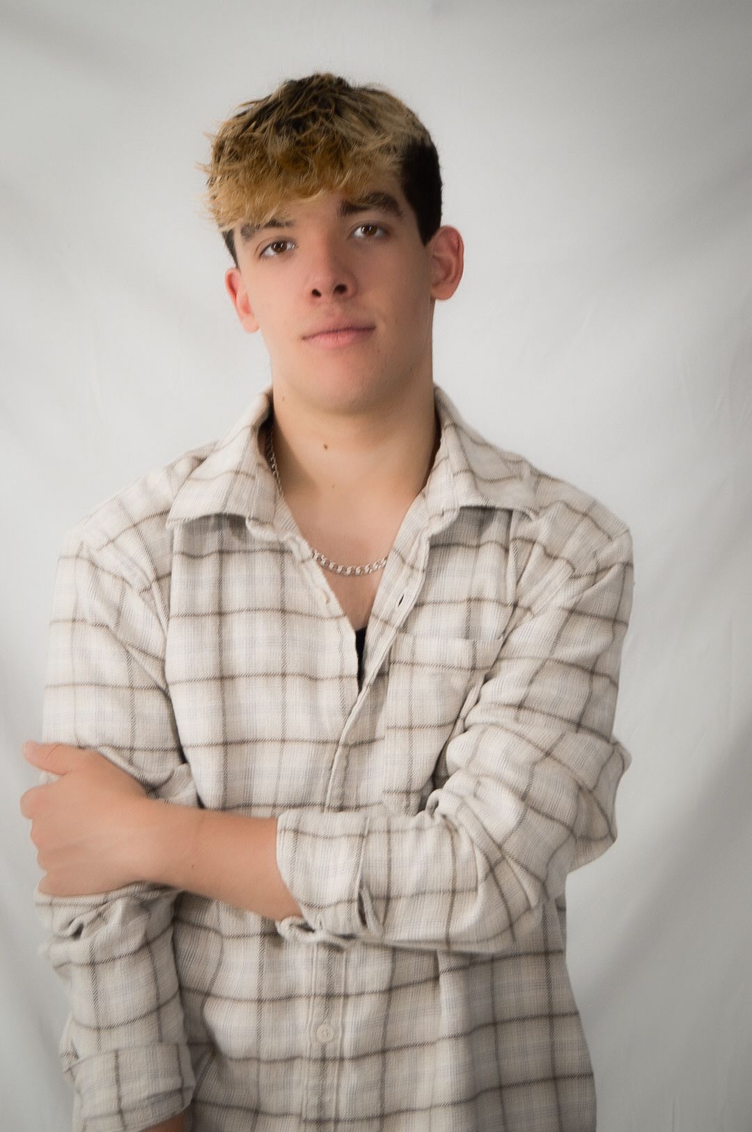 A series of four studio portraits showing someone wearing a plaid button-up shirt against a light gray background.