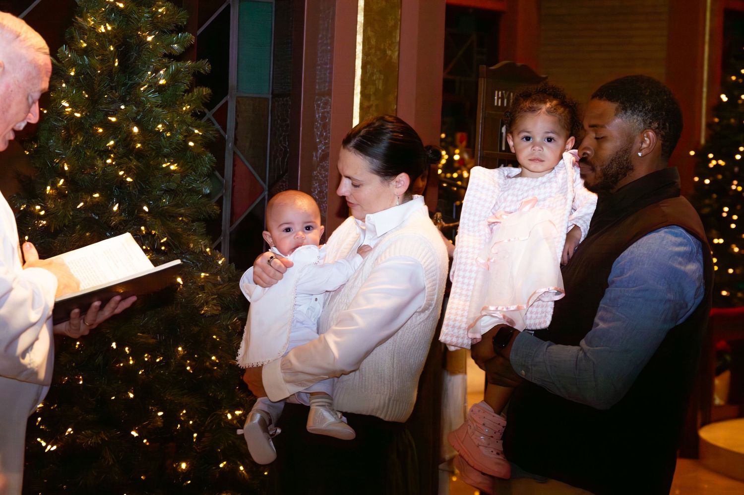 A series of photos showing a baby in white christening attire being held during a baptism ceremony with Christmas trees visible.
