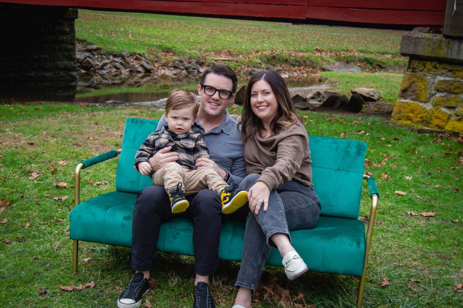 Group relaxing together on a teal outdoor couch in a grassy backyard setting.