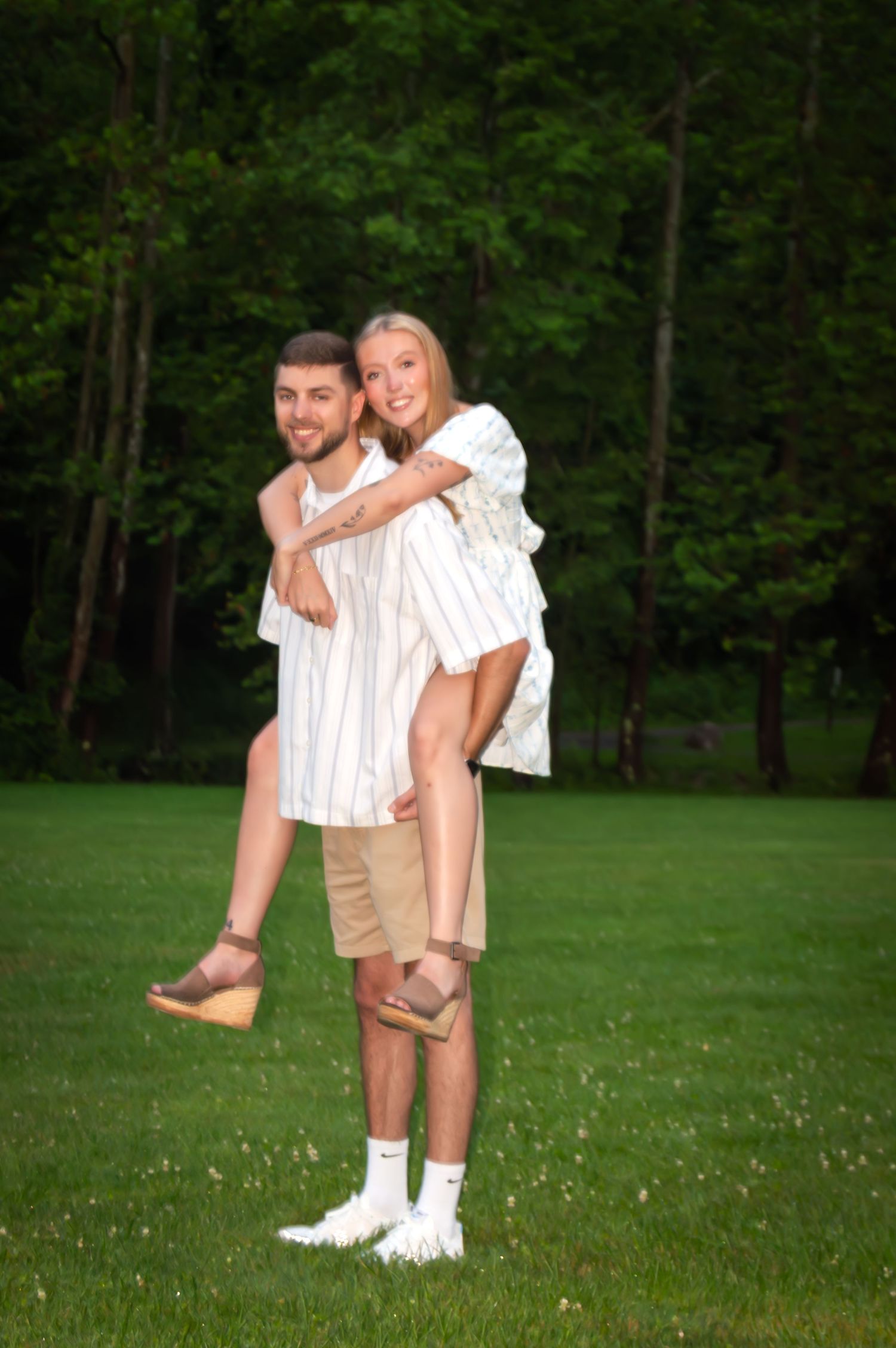 Playful outdoor photo session in a grassy field with natural lighting.
