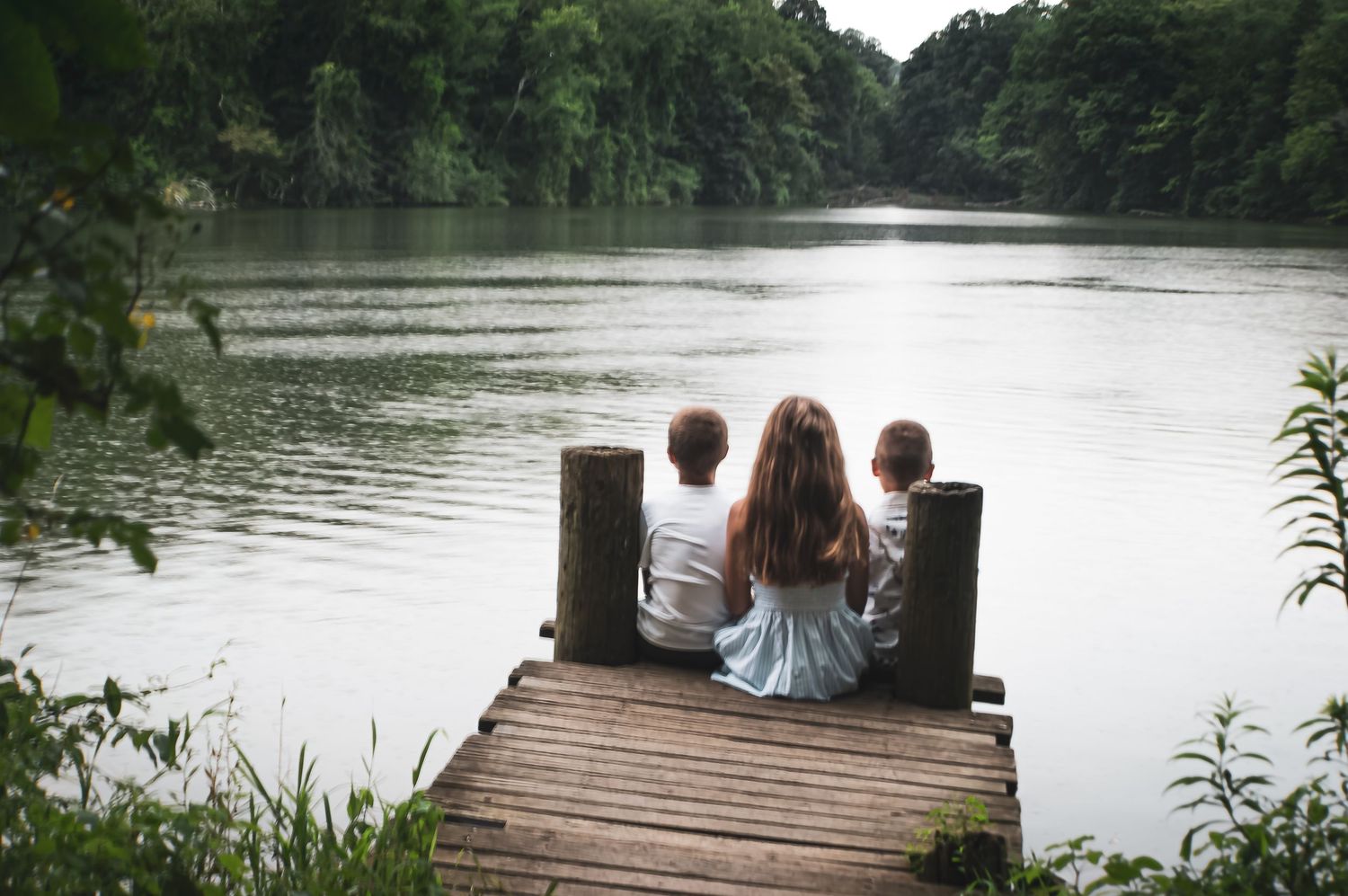 Scenic lakeside dock with family enjoying peaceful summer moment.