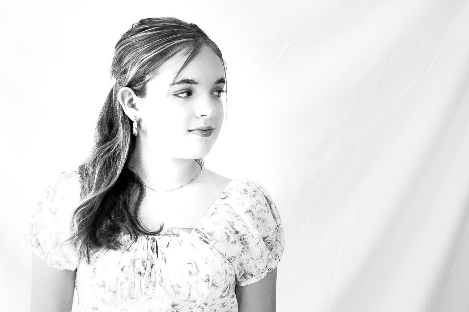 Artistic black and white studio portraits with soft lighting and white backdrop.