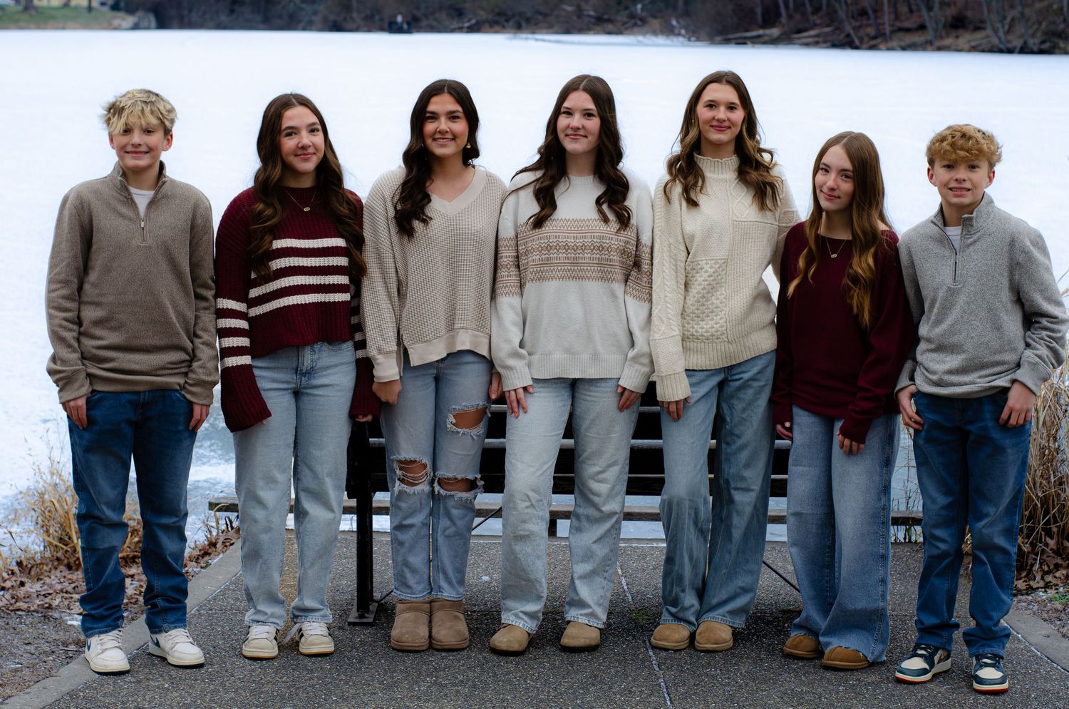 People standing in a row showing only their legs and feet wearing jeans and various casual shoes.