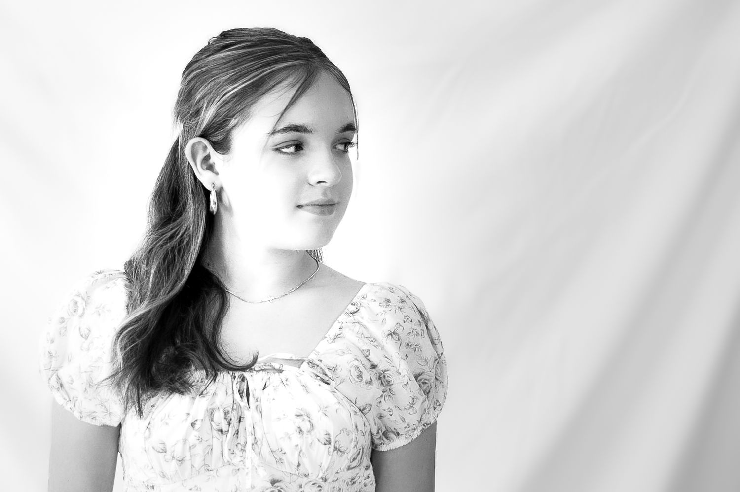 A series of four black and white portraits showing a person in a delicate lace dress against a light background.